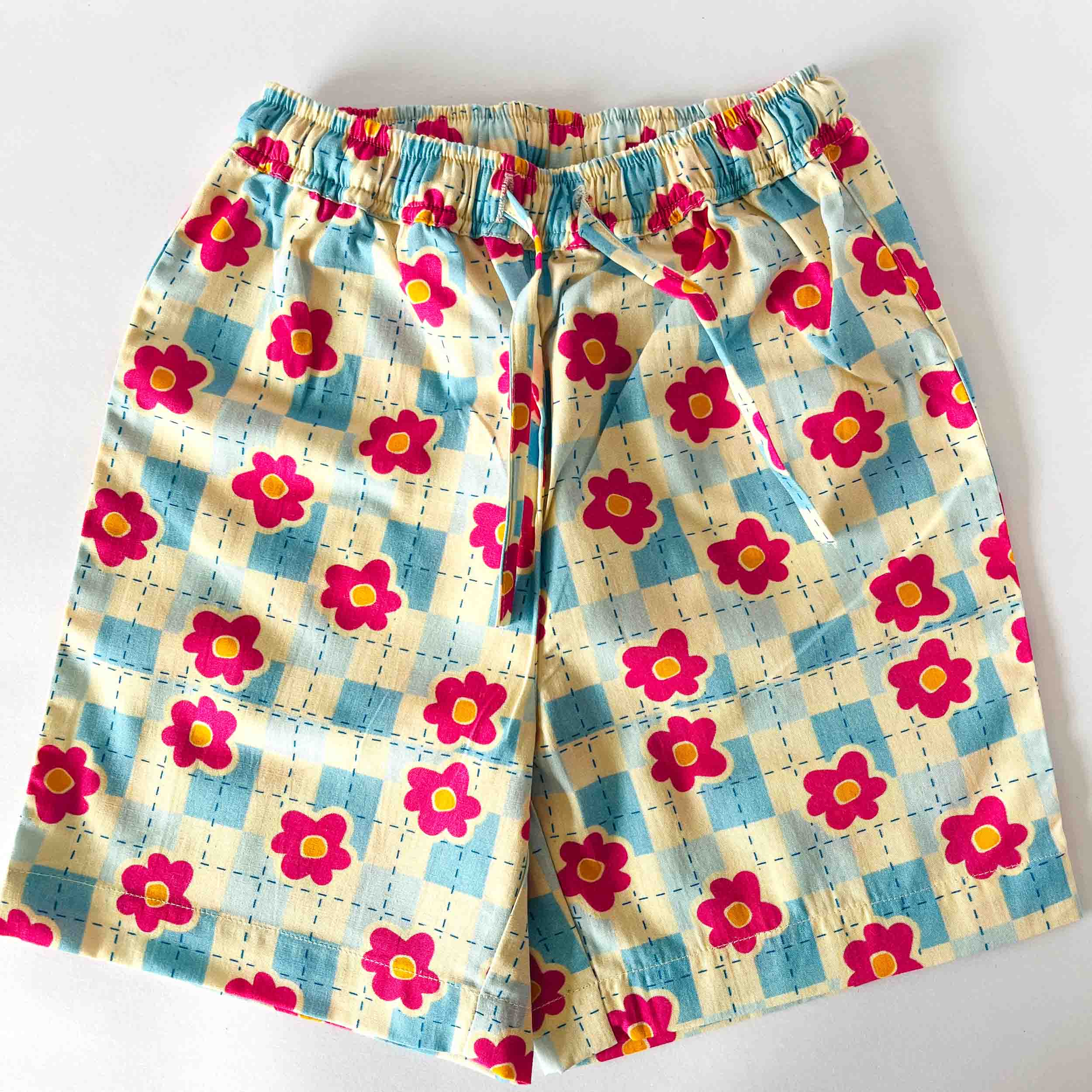 Floral patterned pants with a checkered background on a white background