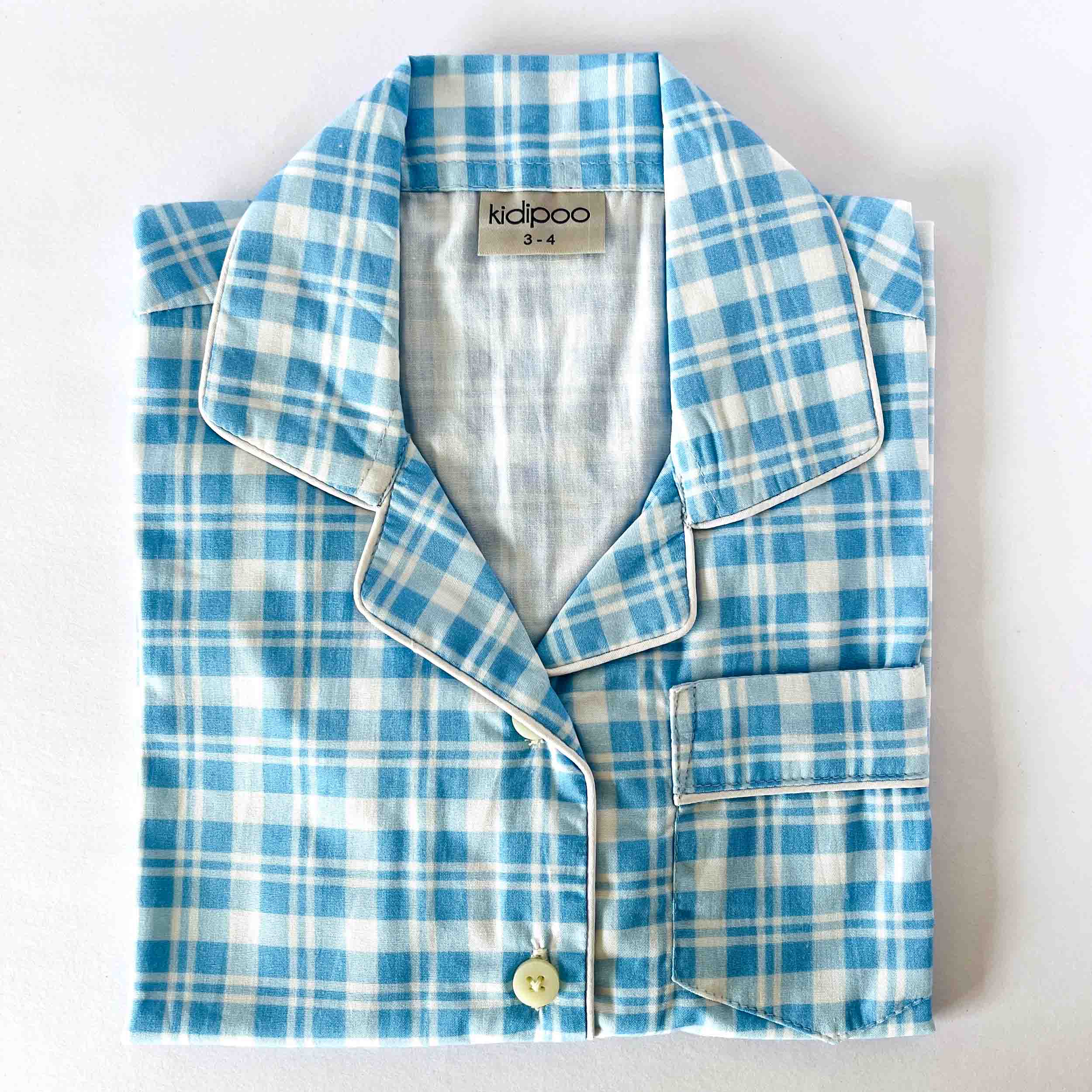 Blue and white checkered pajama set with 'kidipoo' label on a light gray background