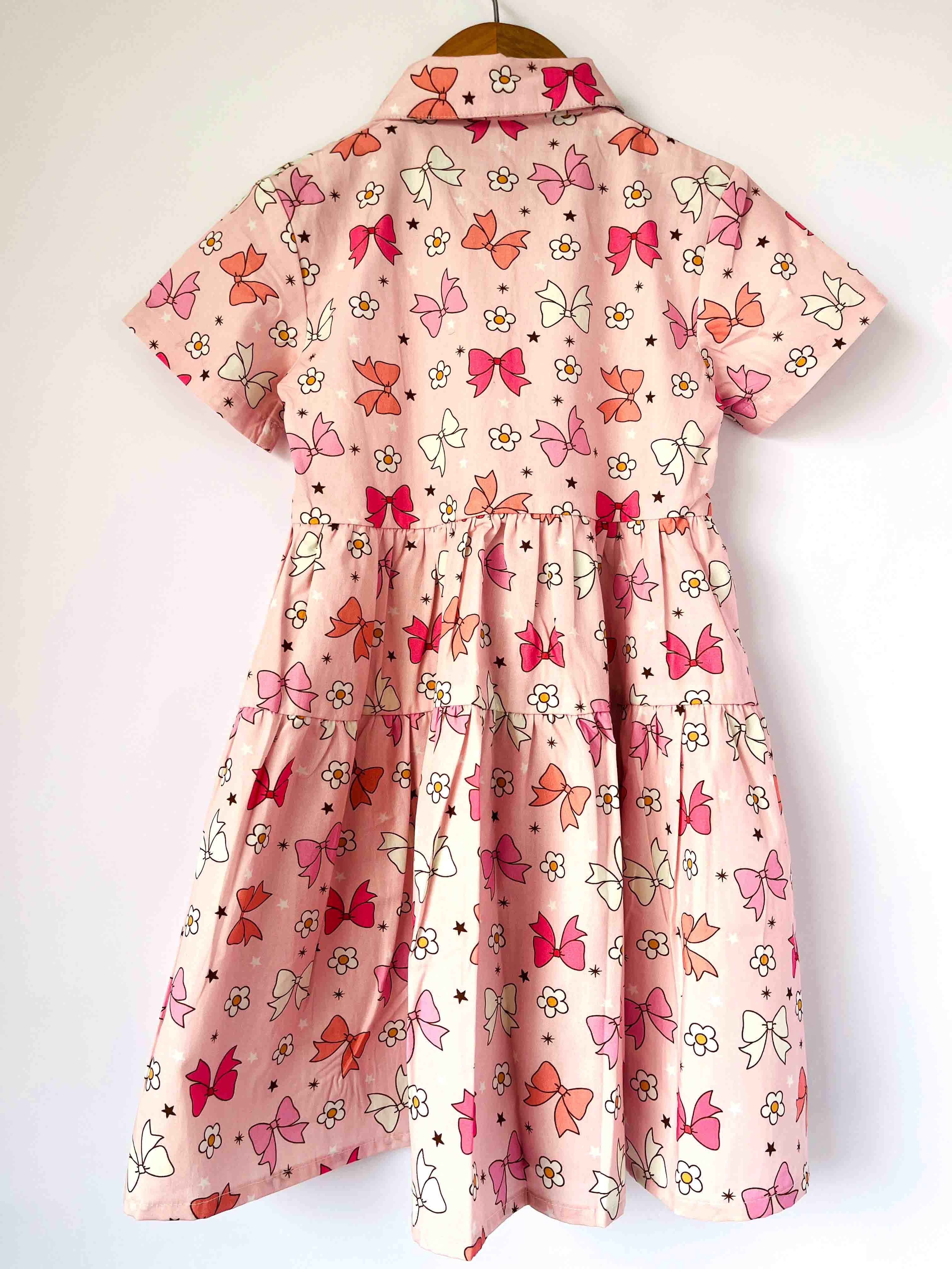 Pink dress with Multi color Bows pattern on a white background