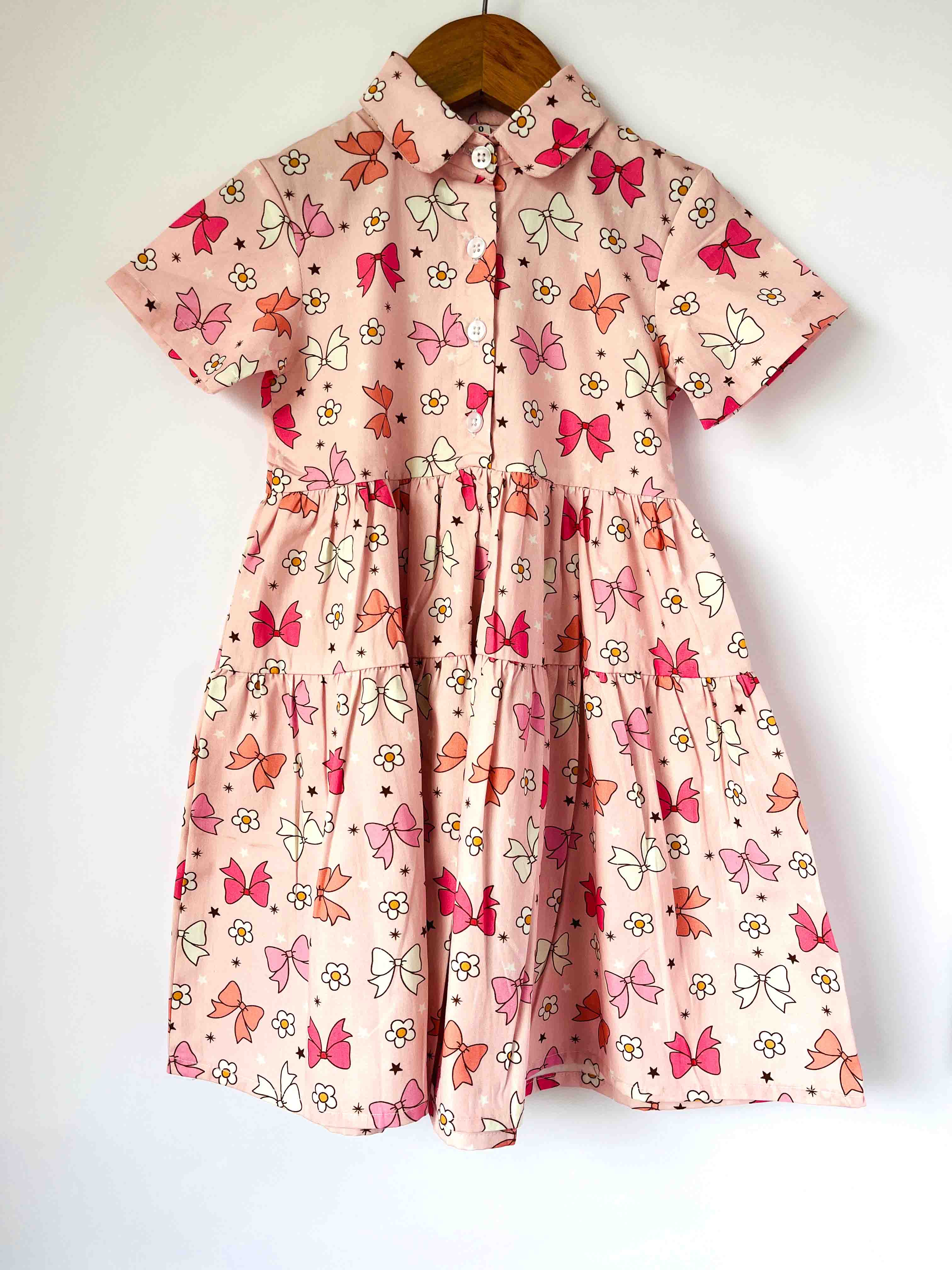 Pink dress with Multi color Bows pattern on a white background