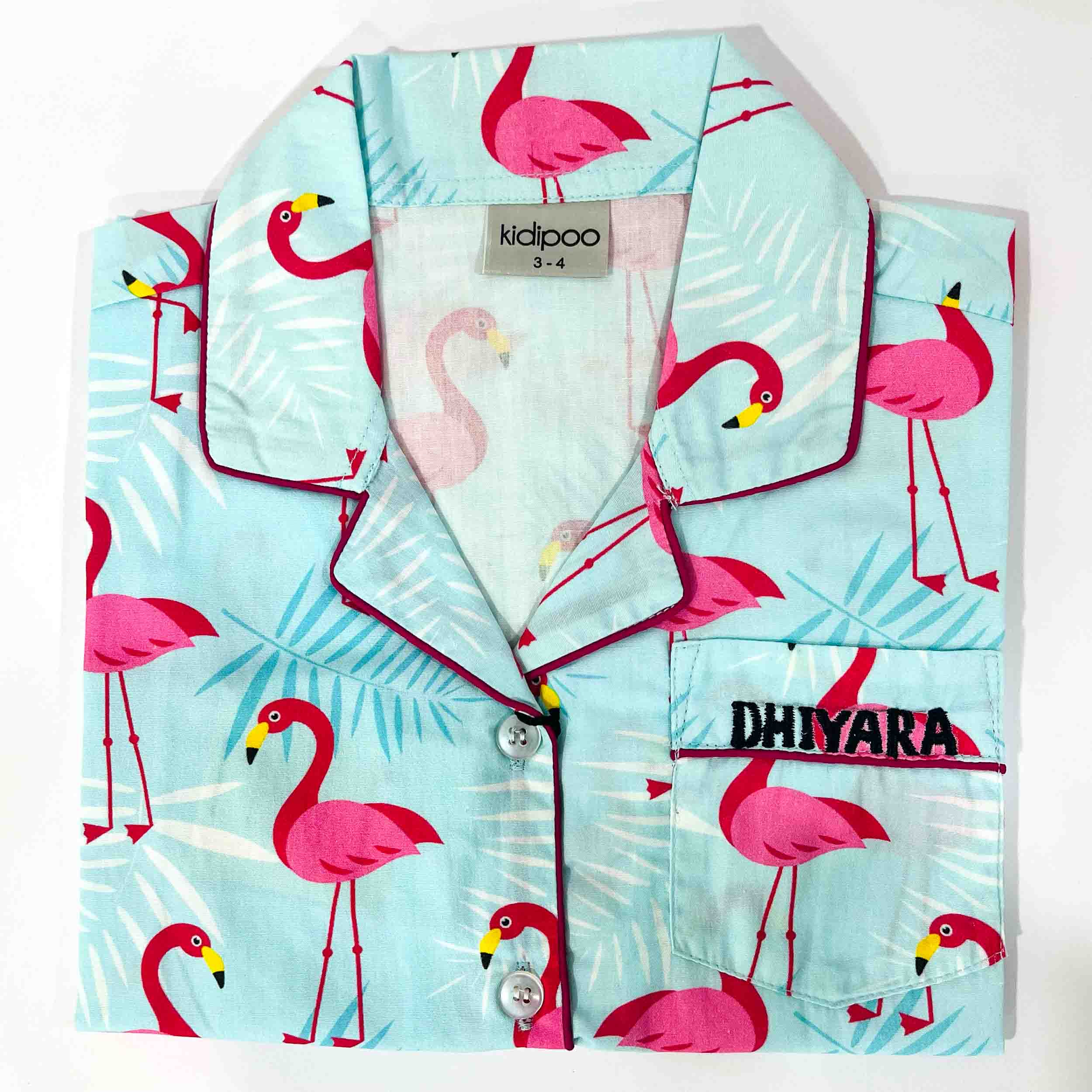 Children's pajama set with flamingo pattern on a light blue background