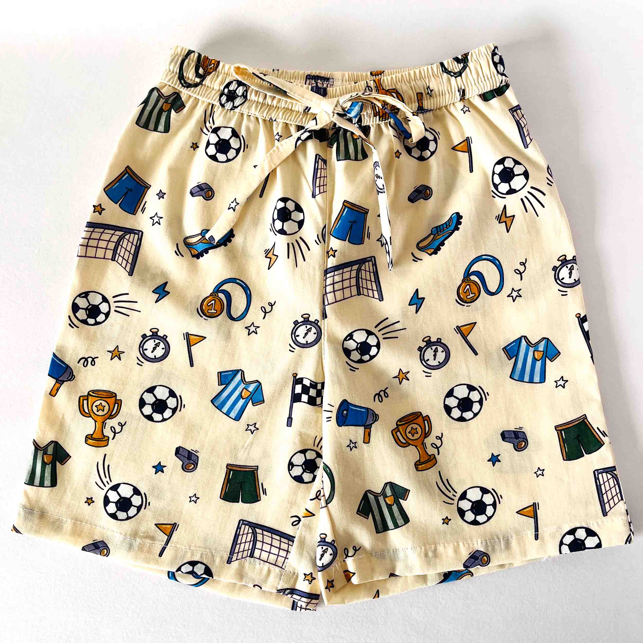 Beige shorts with sports-themed pattern on a white background