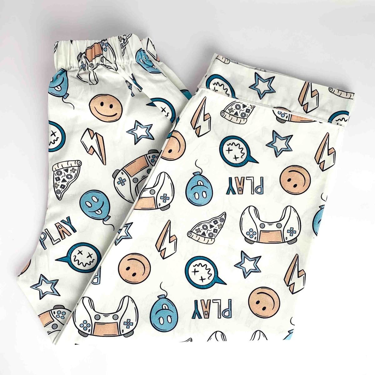 Gaming Squad printed kids' night suit pants with smiley faces, stars, game controllers, pizza, and playful graphic patterns on a white background.