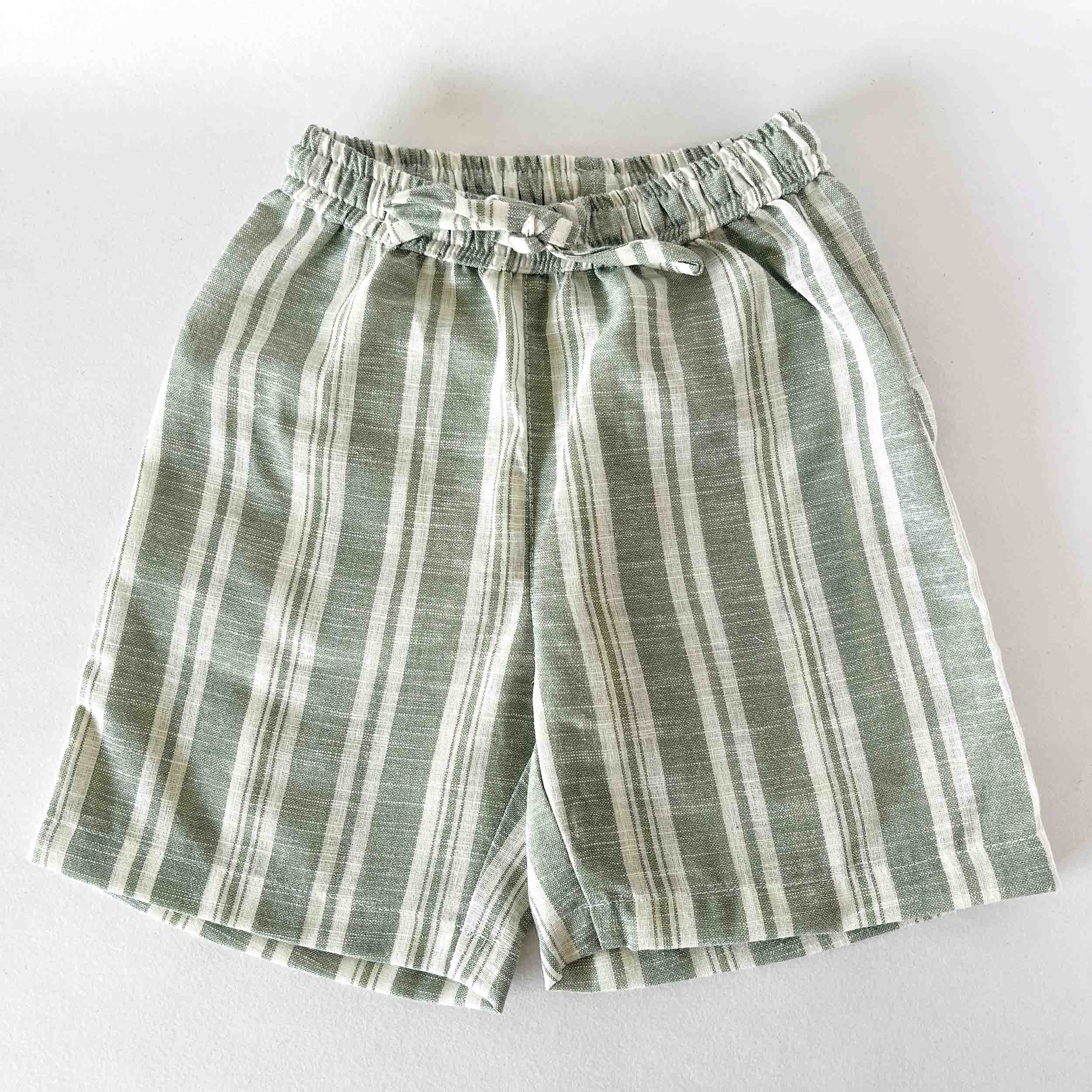 Green and white striped shorts on a light gray background