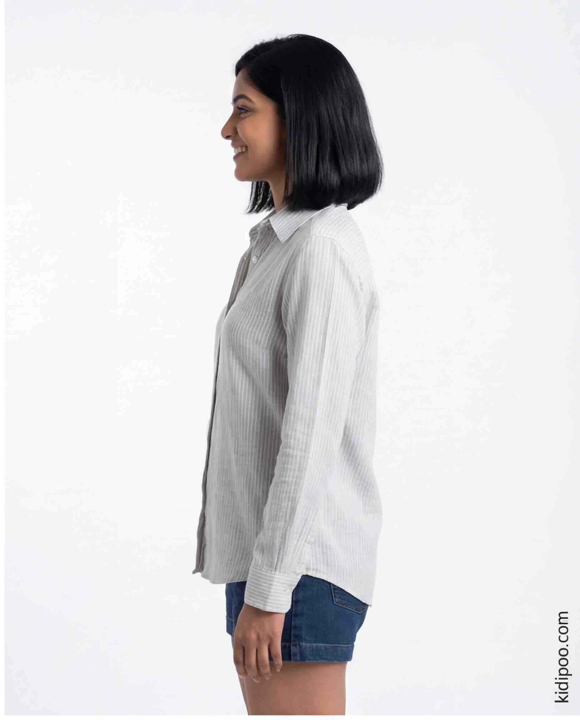 Woman wearing a white shirt with a subtle pattern on a white background