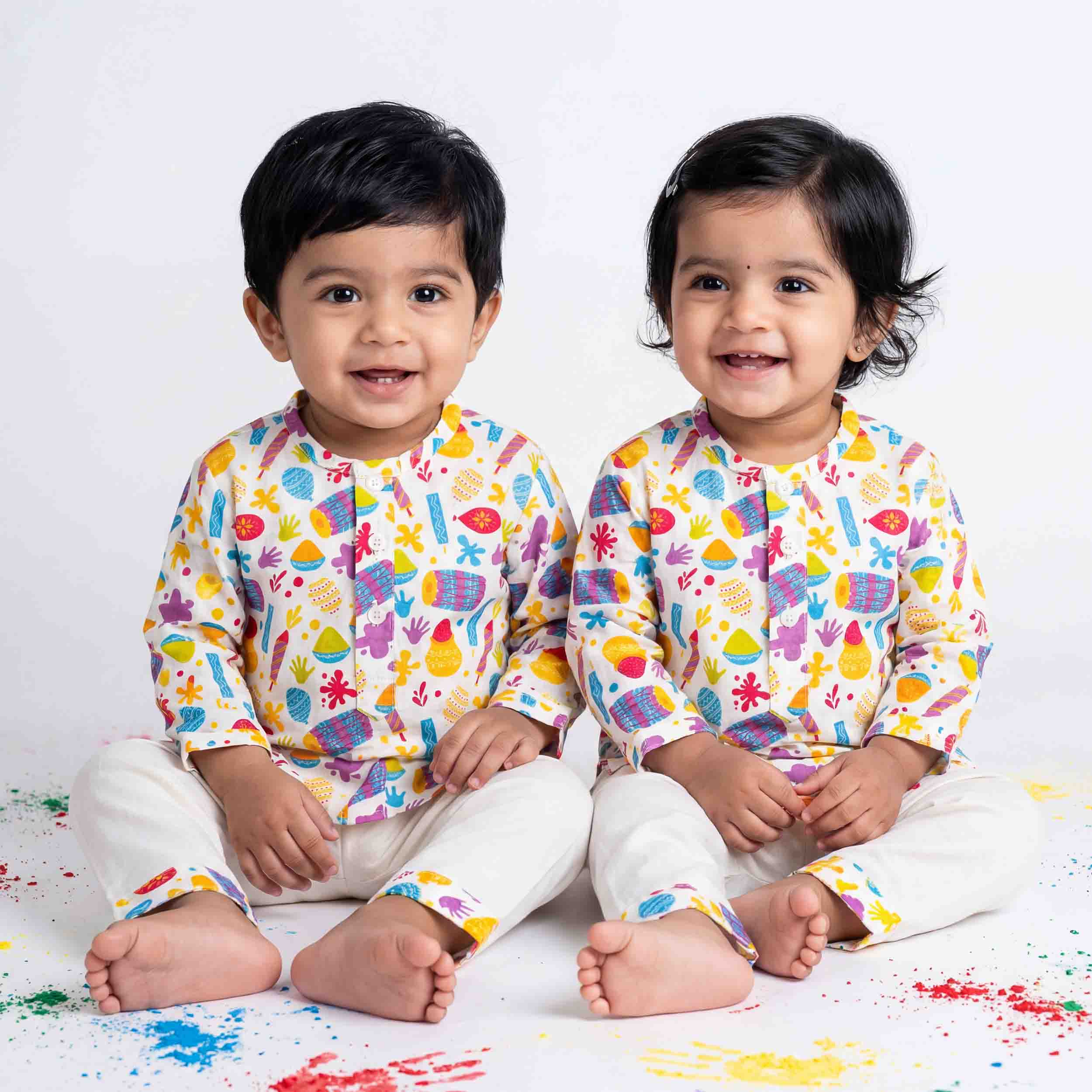 Two children wearing colorful pajamas with a white background