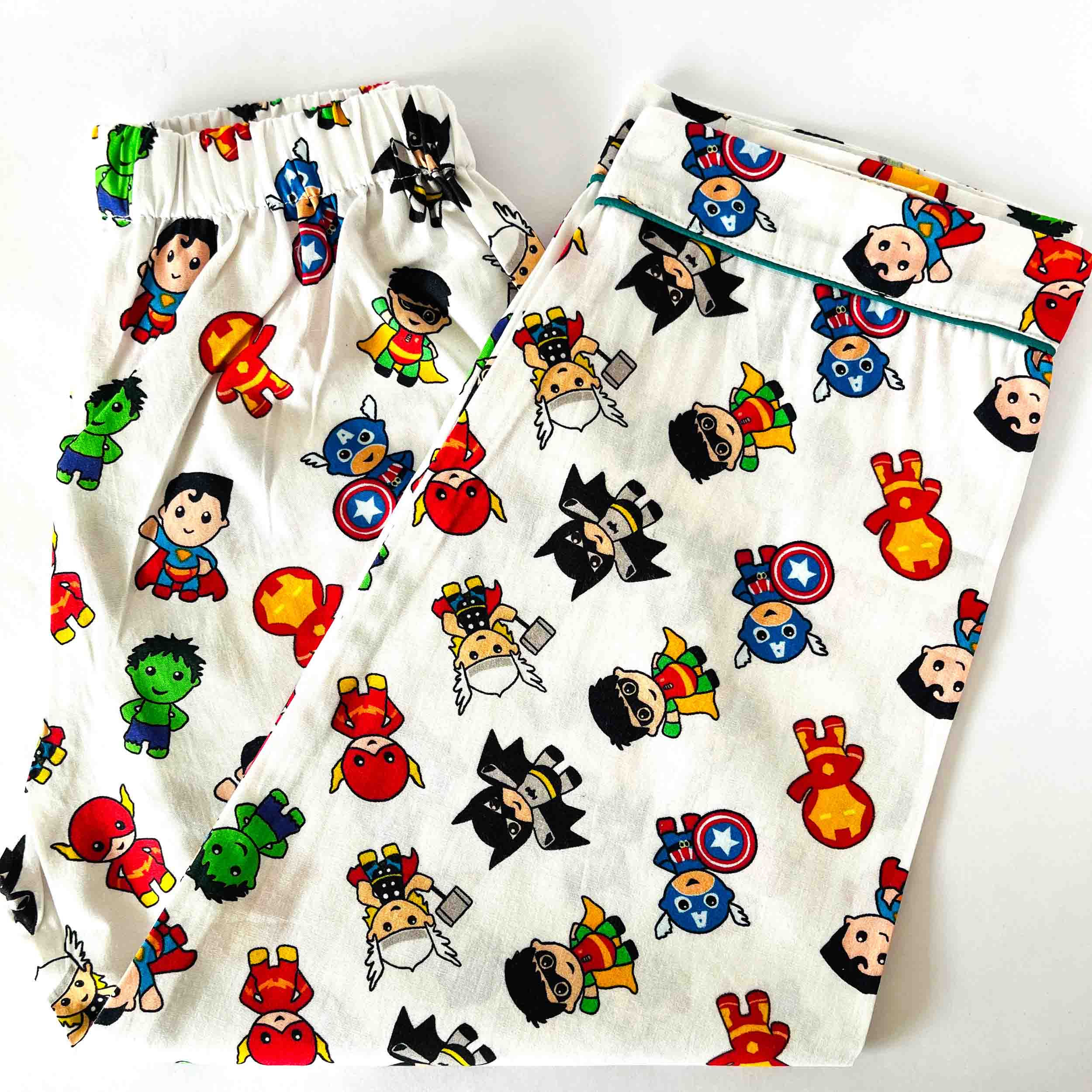 Pair of pajama pants with colorful superhero character pattern on a white background