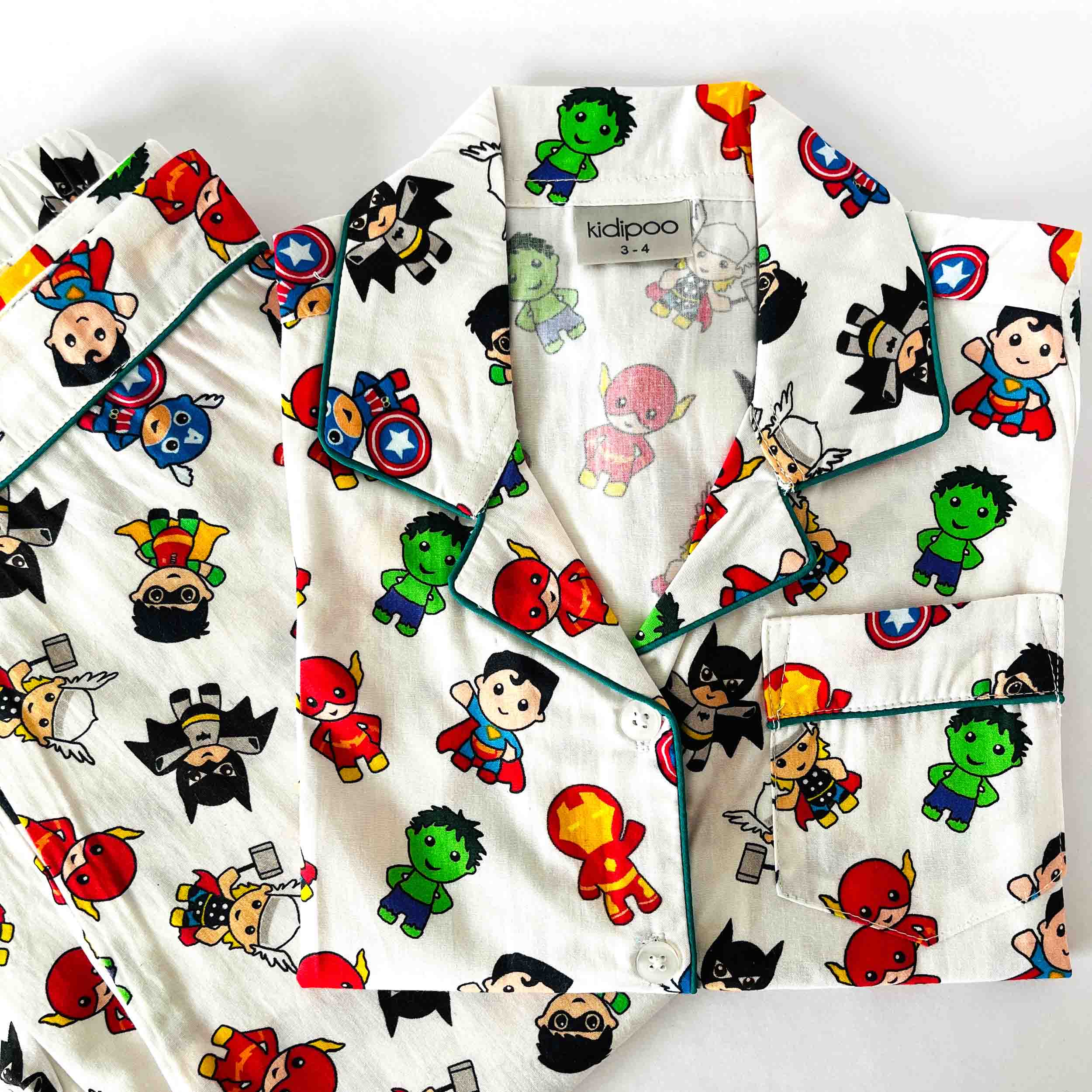 Children's pajama set with superhero and cartoon character prints on a white background