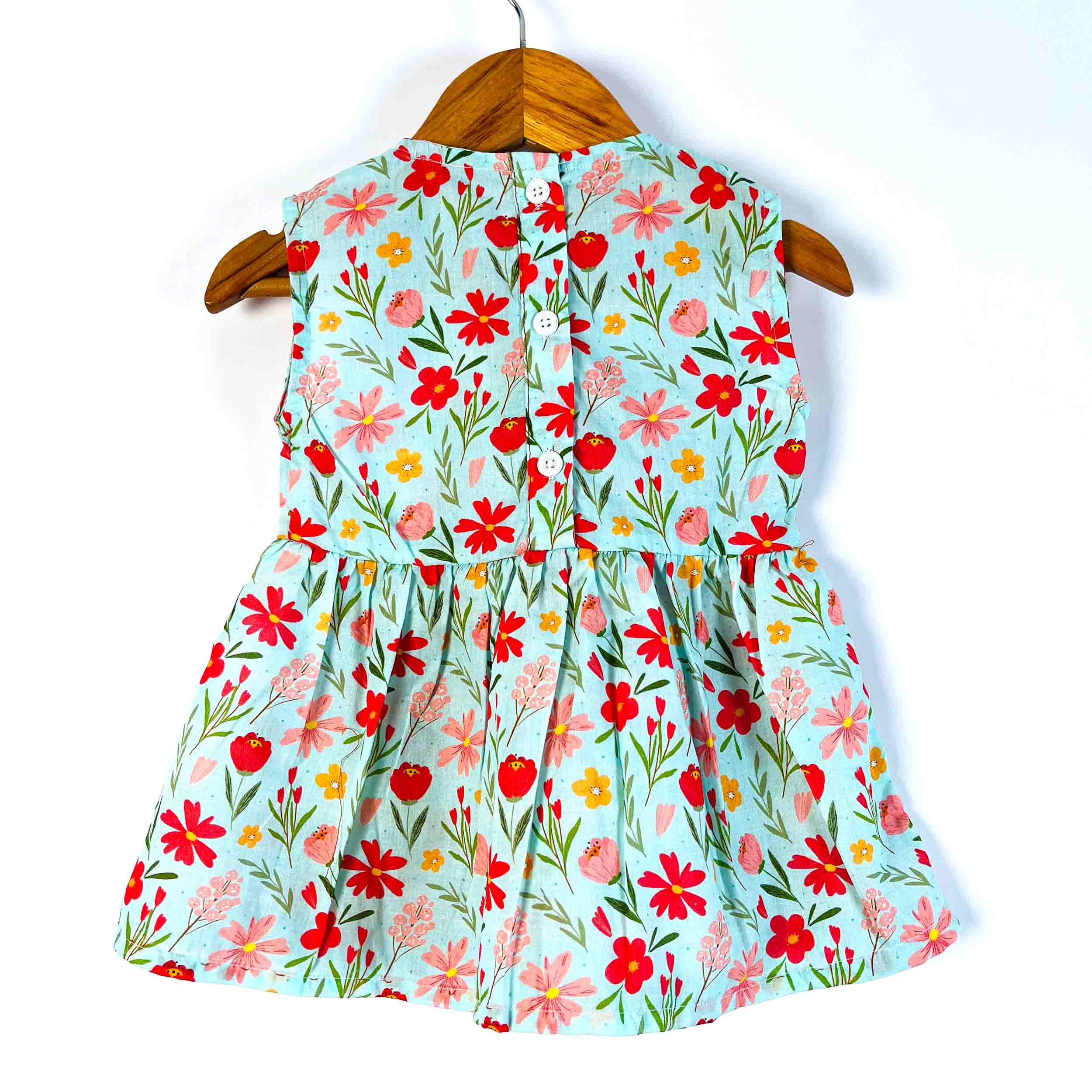 Girls' mint floral sleeveless peplum top back view featuring back button closure, made from 100% premium cotton