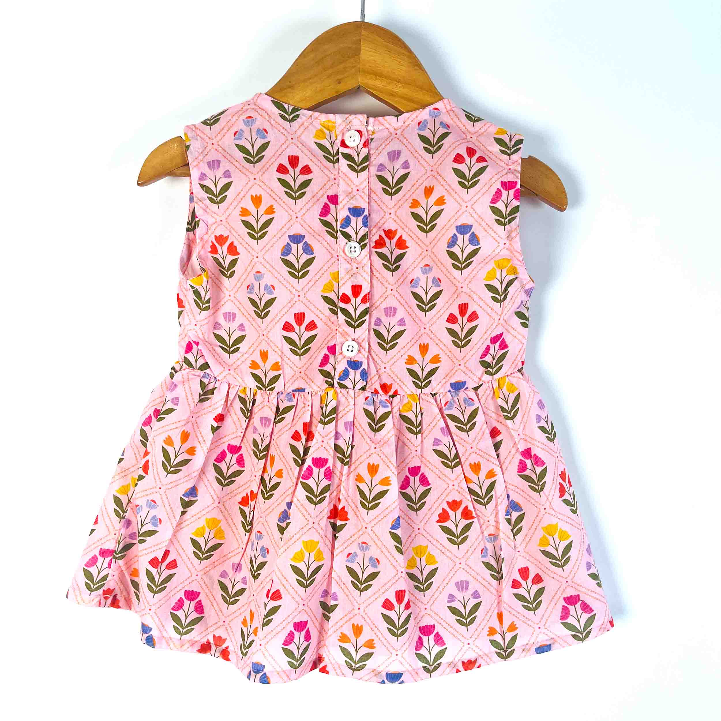 Back view of a Pink Petals sleeveless cotton dress with button-back closure, flared silhouette, and all-over floral print