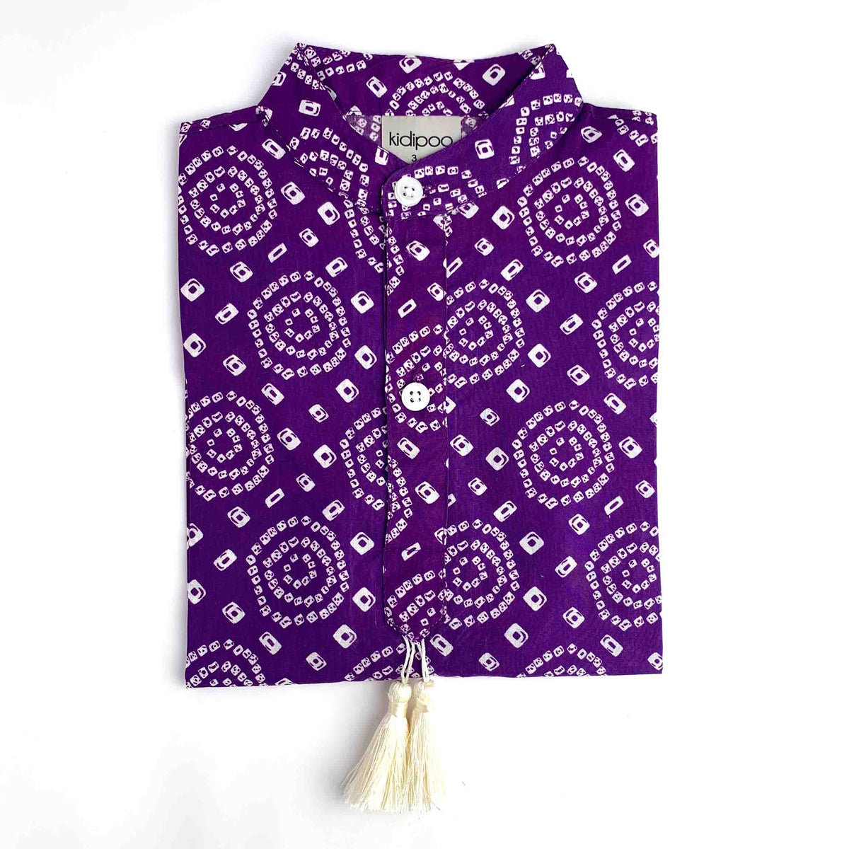 Purple Bandhani Kurta for Kids with white Bandhani print, button-up front, collared neckline and cream tassel on a white background.
