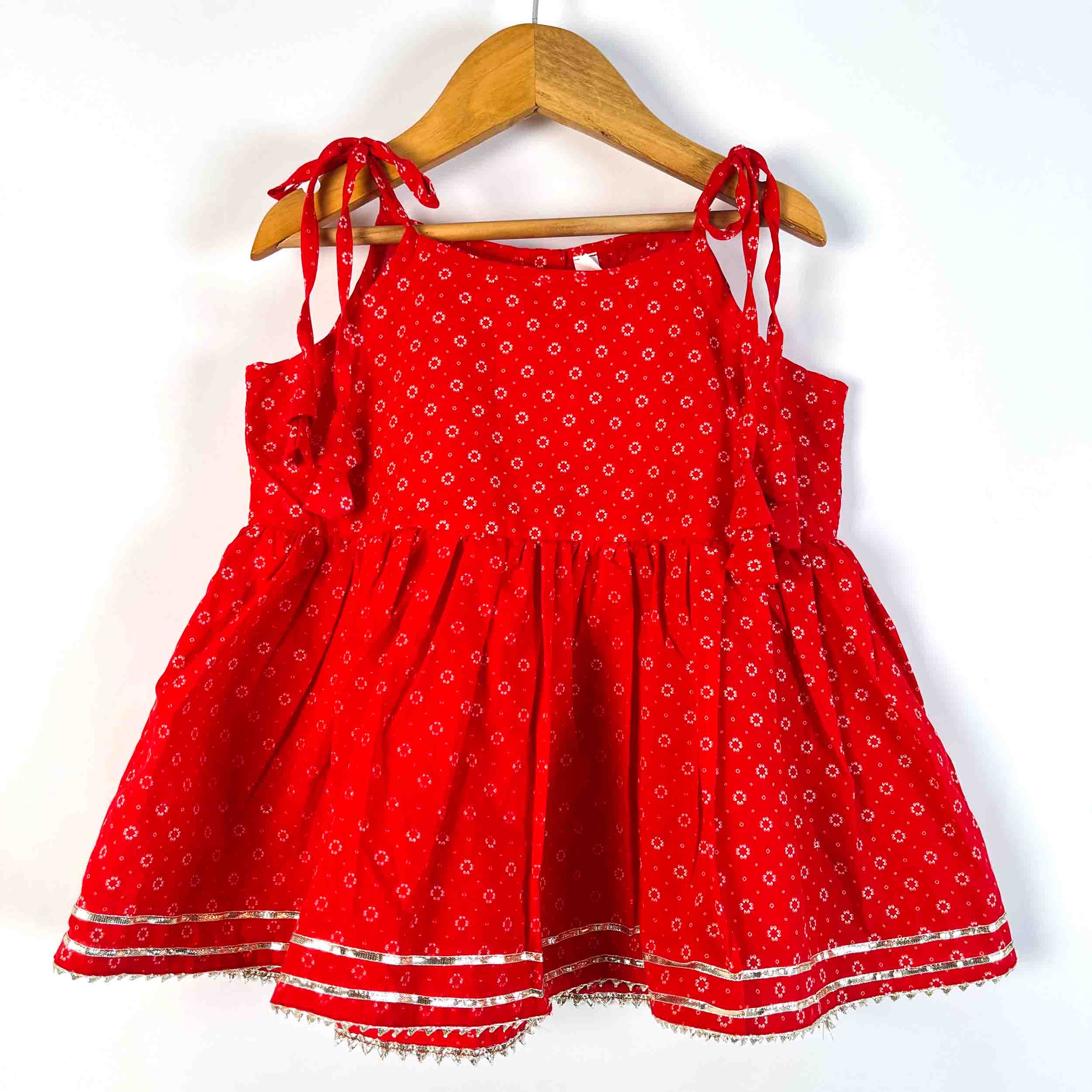 Girls Red Utsav Sharara Set with sleeveless tie-up kurti featuring white printed motifs and matching flared sharara in 100% cotton