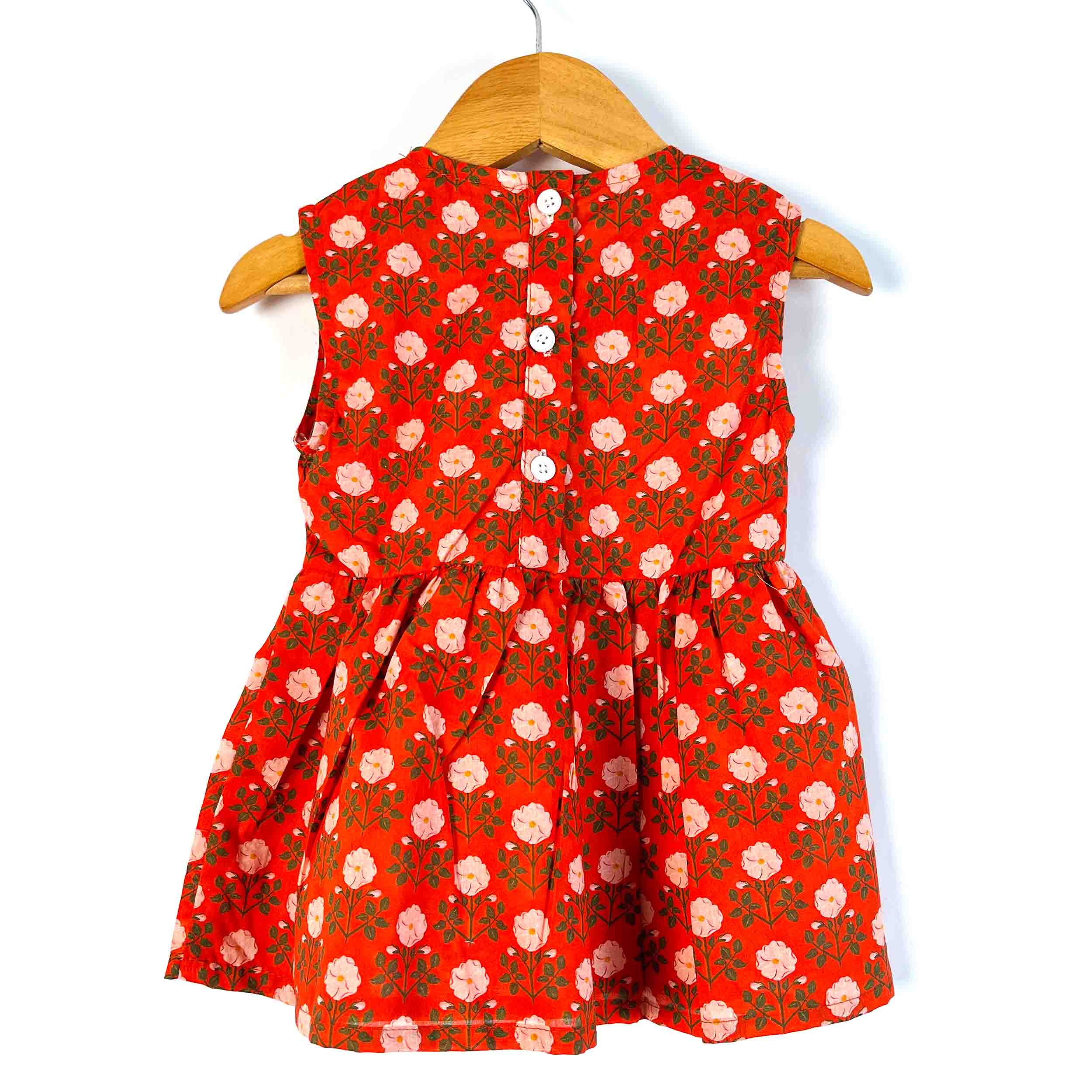 Girls' red floral sleeveless peplum top back view featuring back button closure in 100% cotton fabric