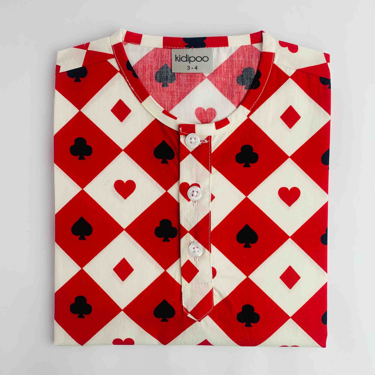 A folded long-sleeve kurta by Kidipoo, featuring a red and white harlequin diamond pattern with black playing card suits (clubs, hearts, diamonds, spades) and a three-button placket.
