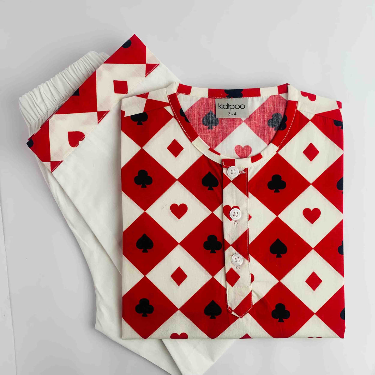 A folded Kurta pajama set from kidpoo, featuring a red and white diamond-patterned top with black playing card suit symbols and a matching folded pair of white pants with a red and black heart pattern.