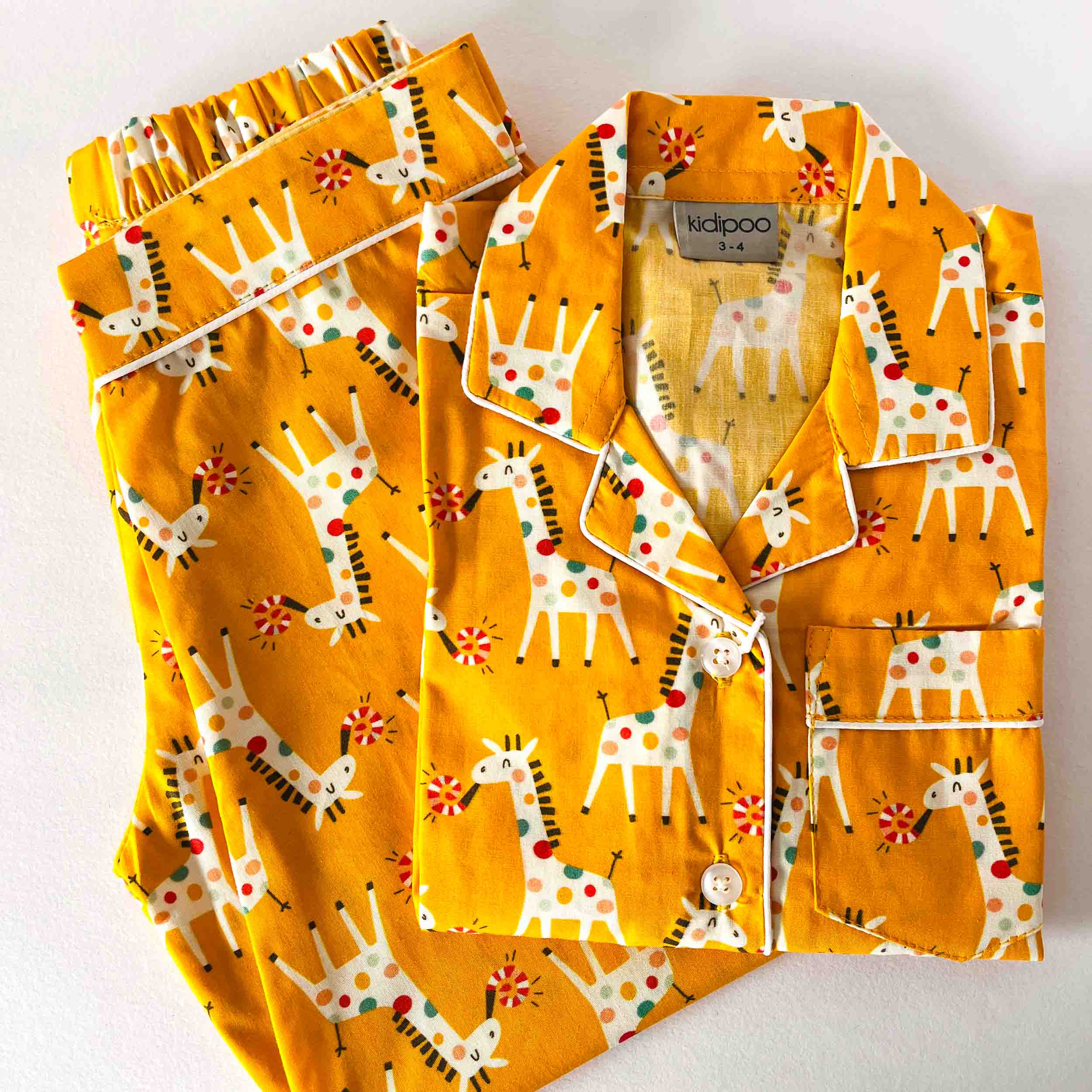 Children's pajama set with giraffe pattern on a white background