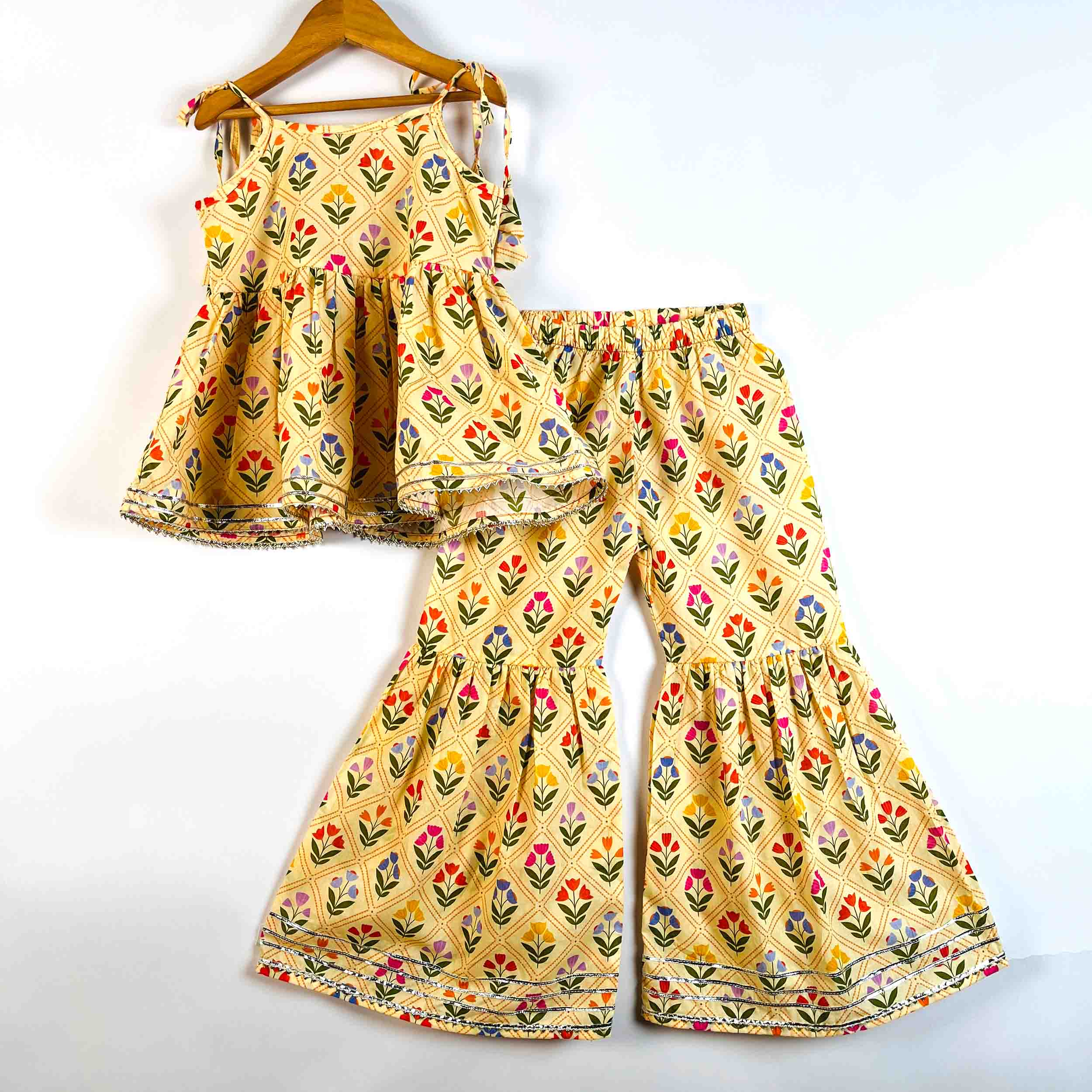 Girls Yellow Petals printed cotton sleeveless tie-up kurti with matching sharara set in floral print