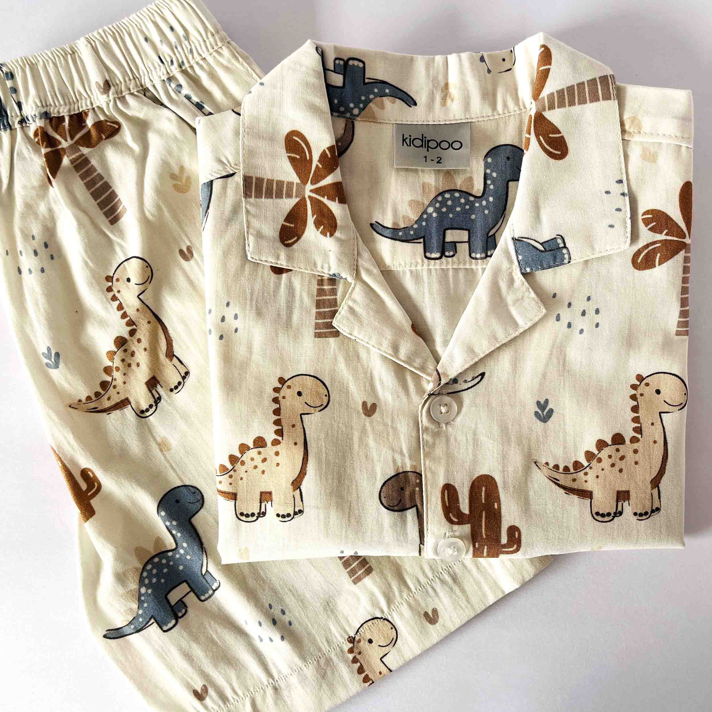 Children's pajama set with dinosaur pattern on a light background