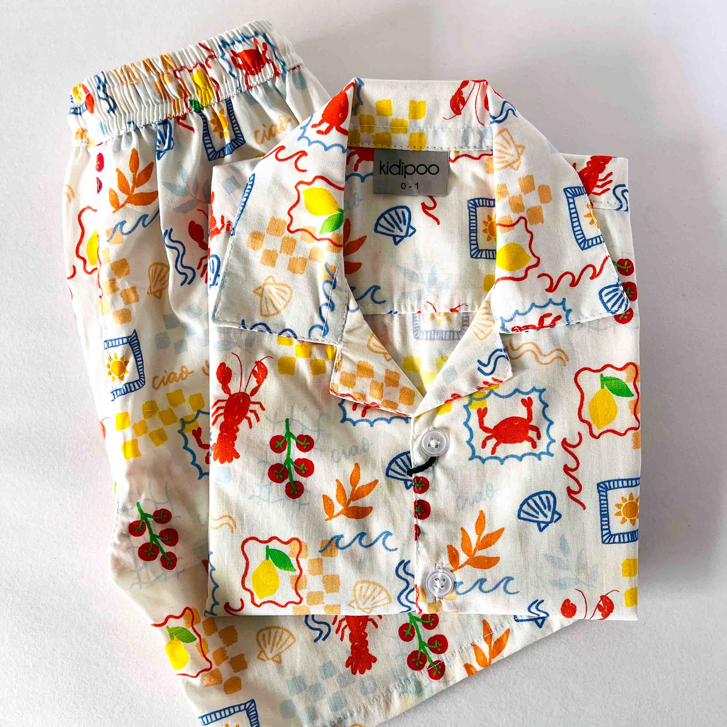 Children's outfit with colorful sea-themed pattern on a white background