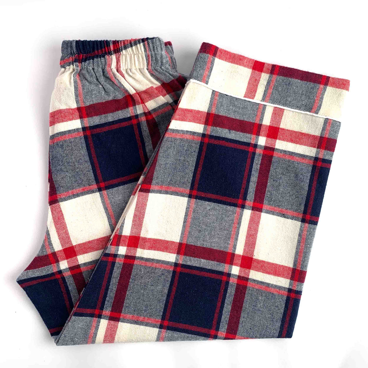 A pair of plaid lounge pants folded on a white background, featuring a pattern of navy blue, red, and cream.