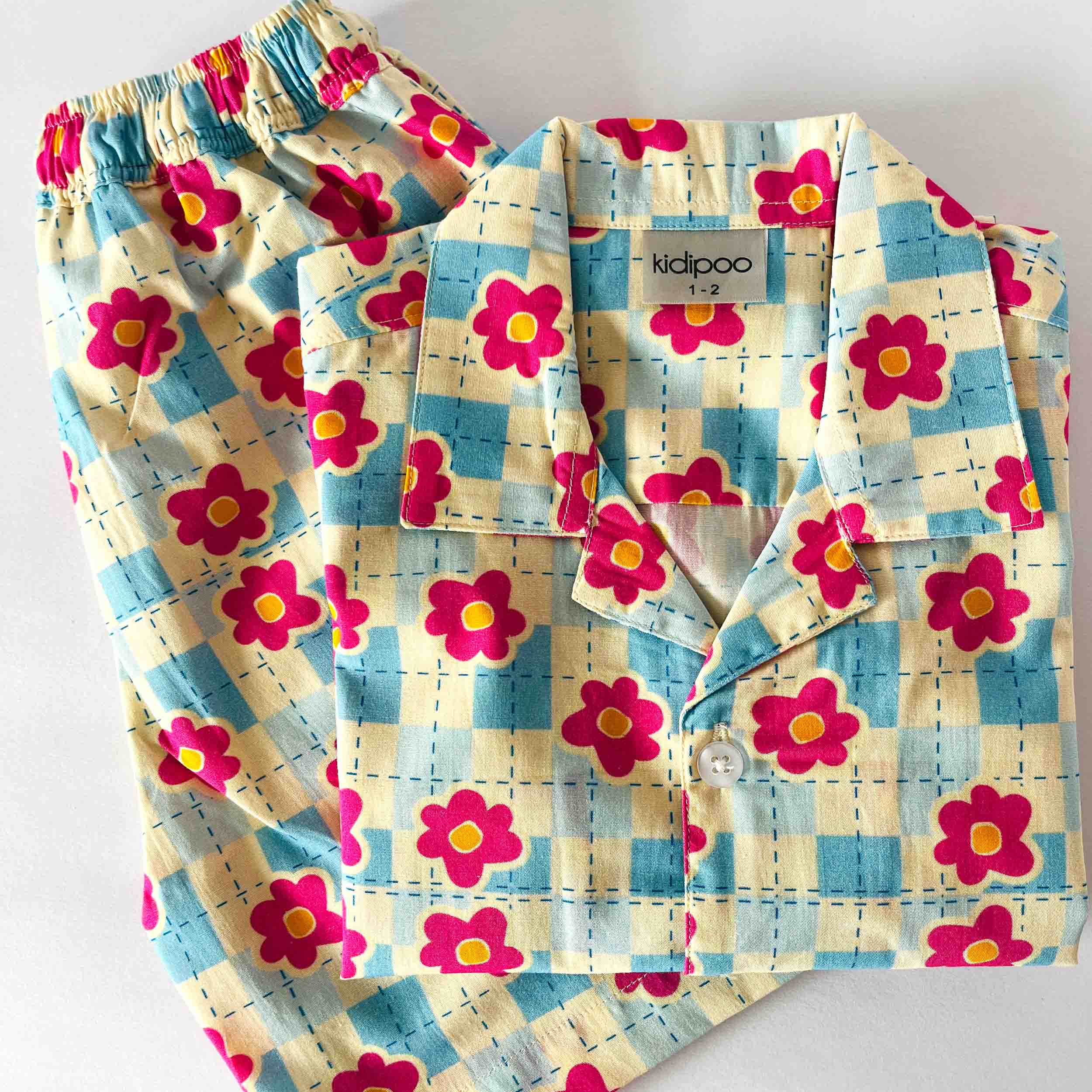 Floral patterned pajama set with matching shirt and pants on a white background