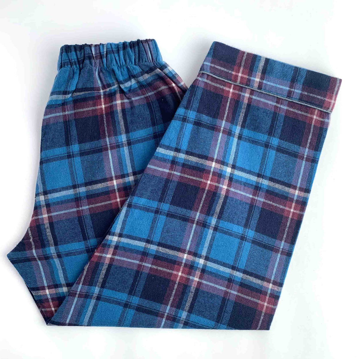 Blue plaid lounge pants with an elastic waistband, folded on a white background.