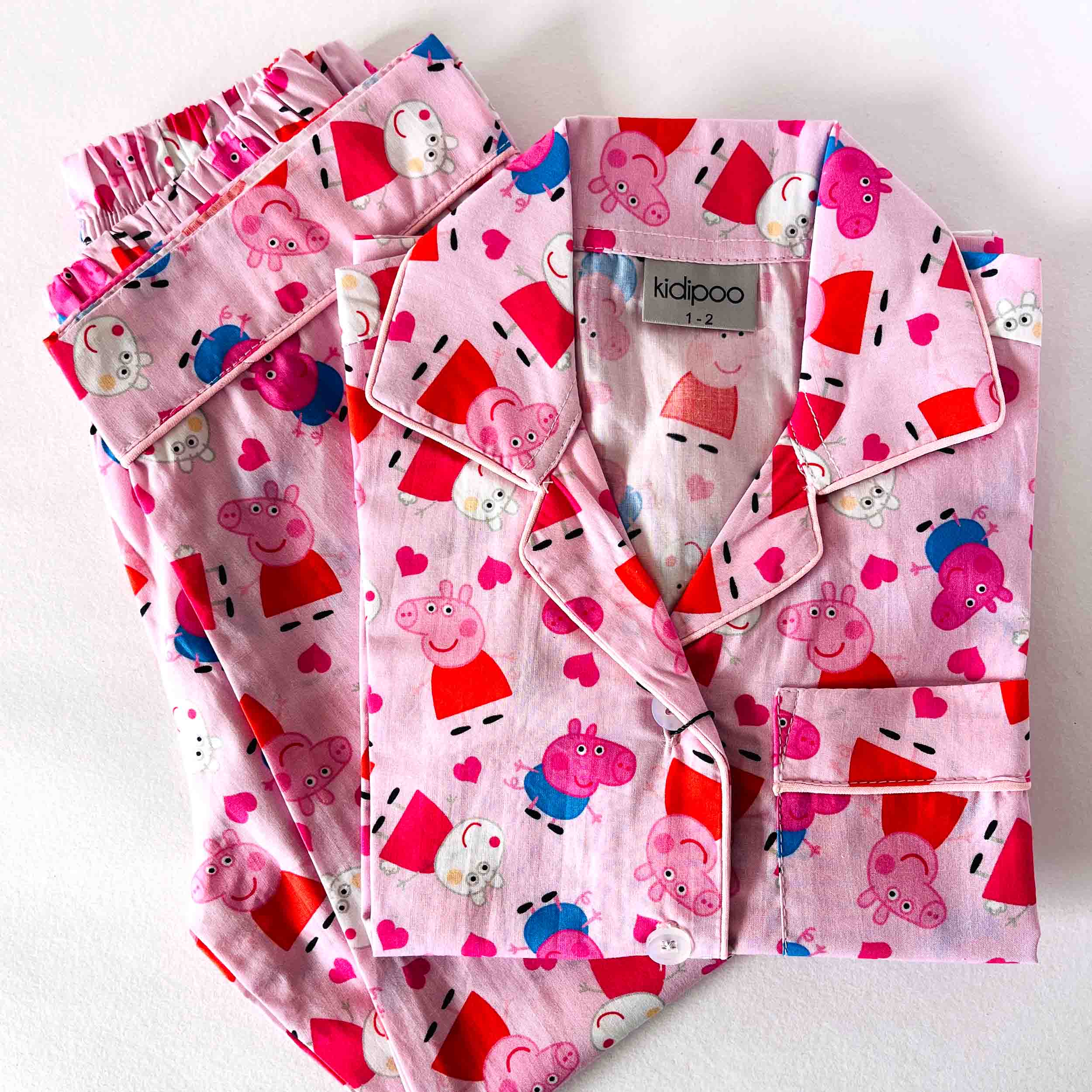 Pink children's pyjama set with Peppa Pig design on a white background