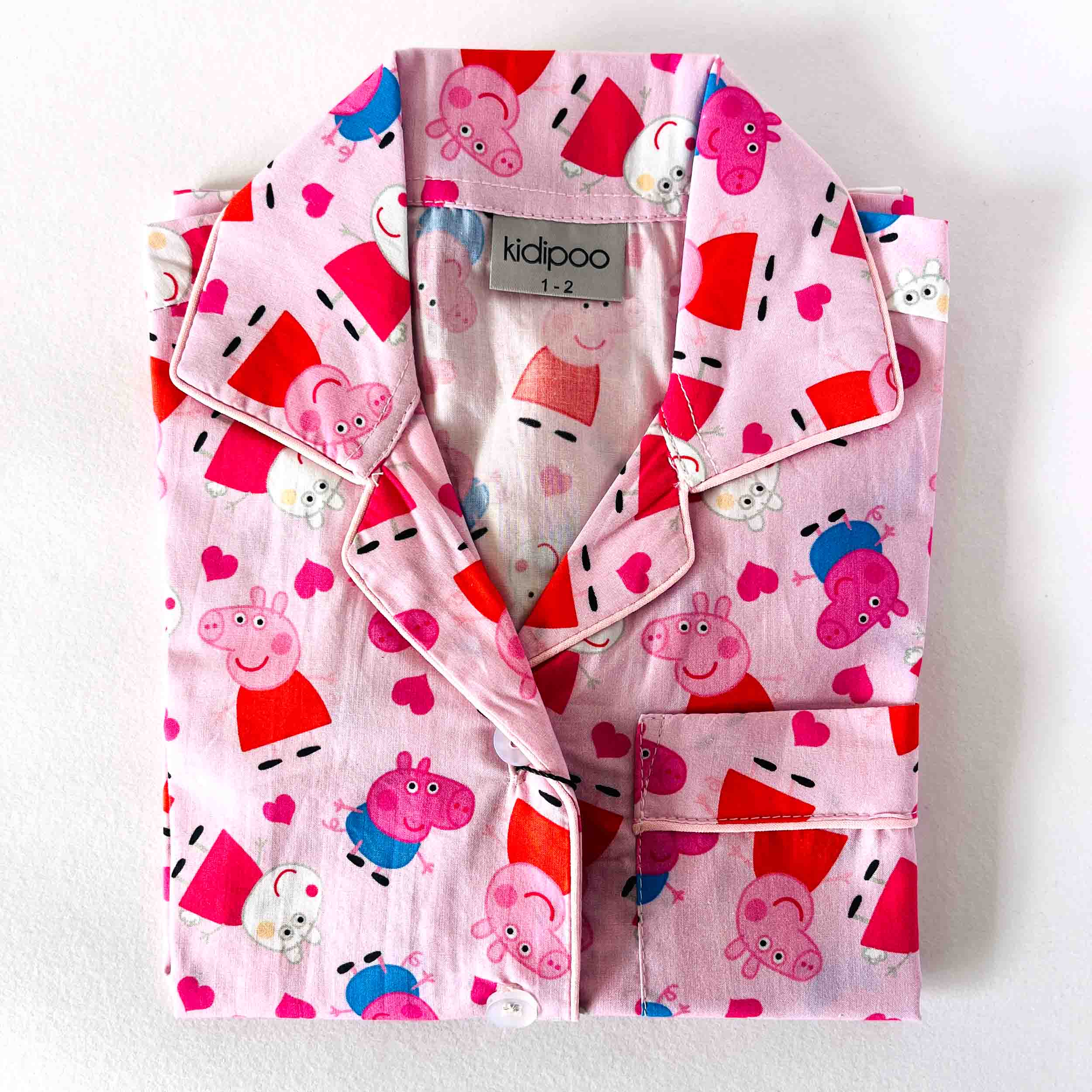 Pink children's shirt with Peppa Pig pattern on a white background