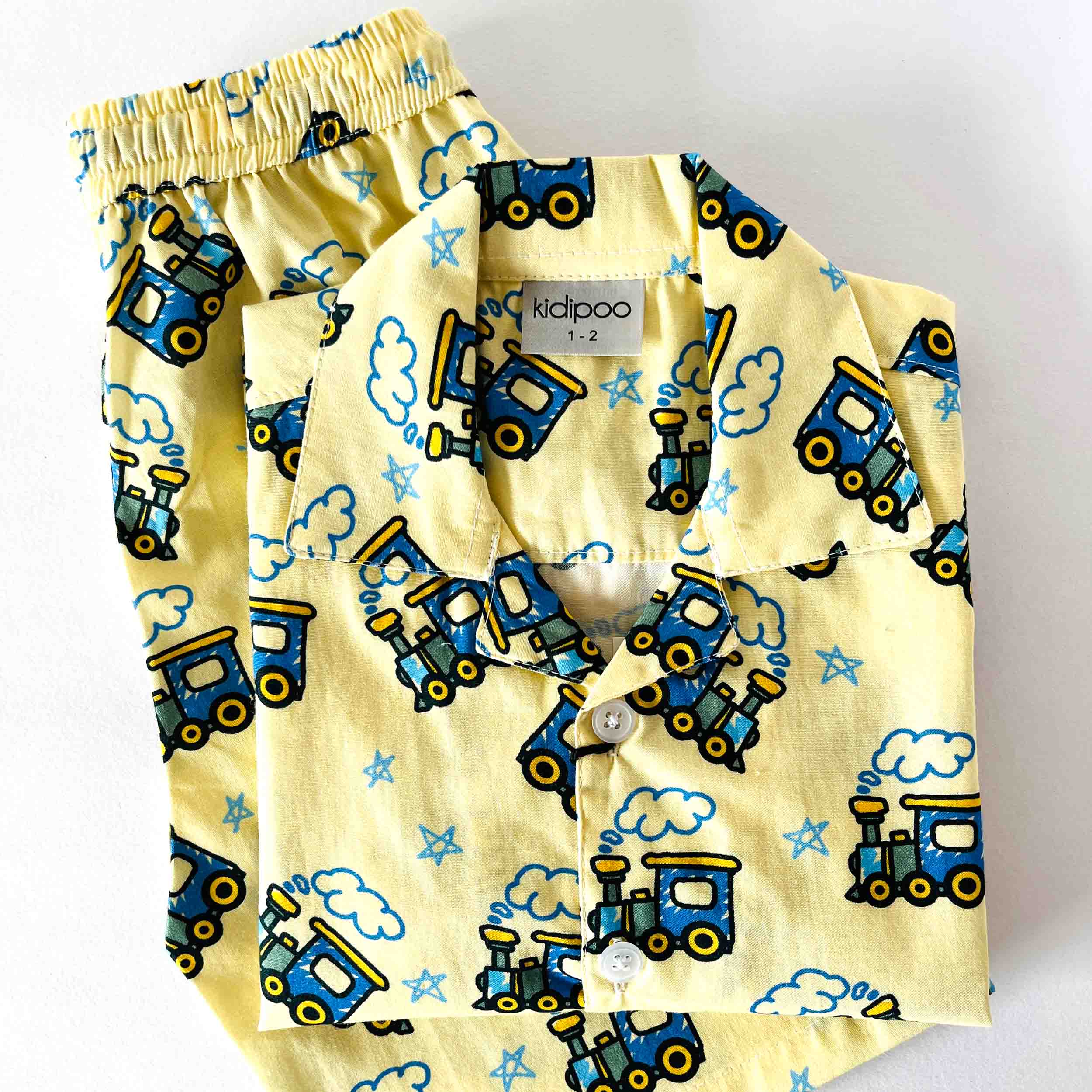 Children's pajama set with train pattern on a yellow background