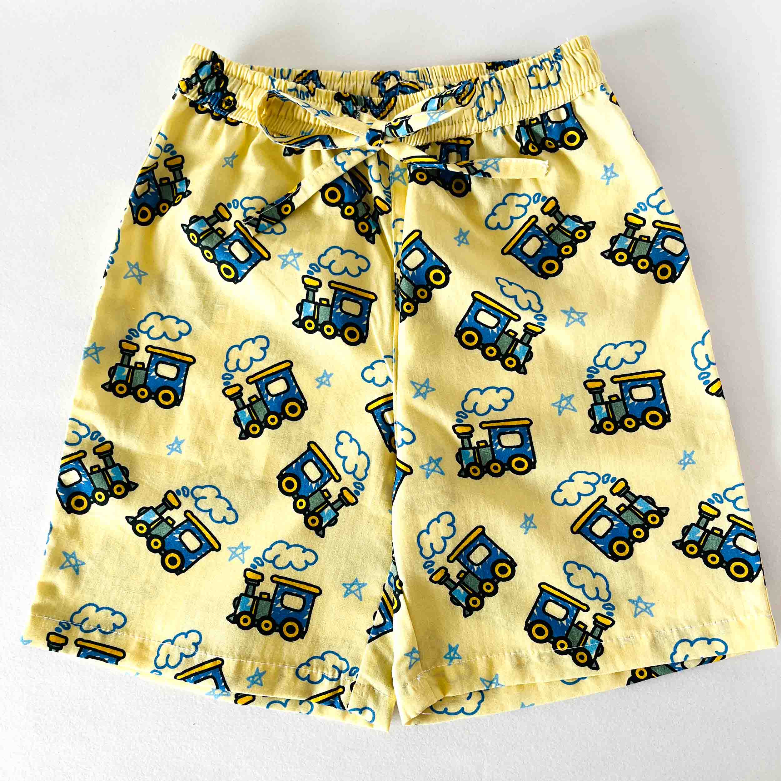 Yellow children's shorts with blue train pattern on a white background