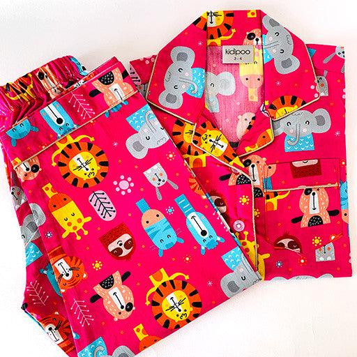 A set of children's pajamas with a colorful circus animal theme, including a long sleeve shirt and pants, laid out on a white background.