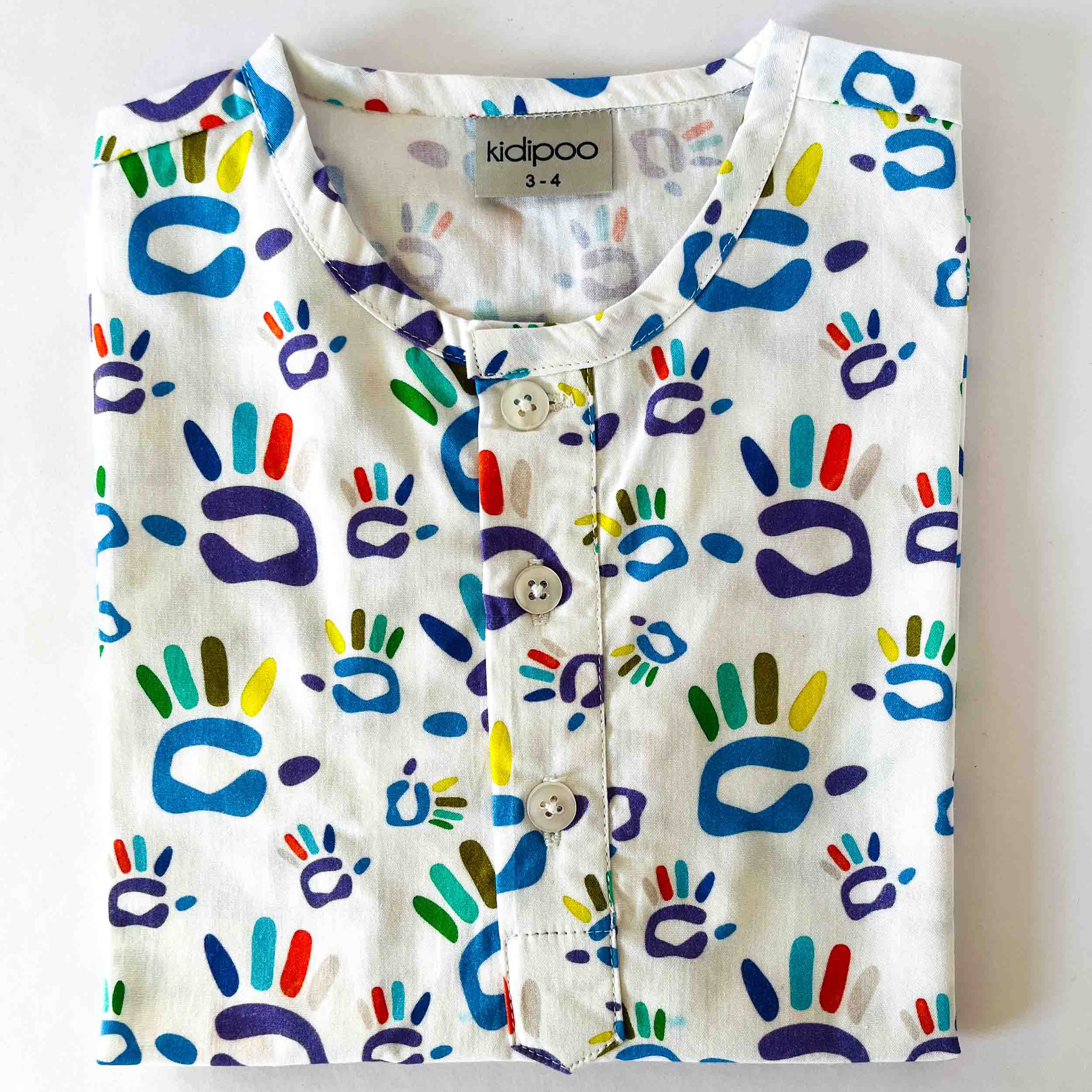 Children's shirt with colorful hand print pattern on a white background