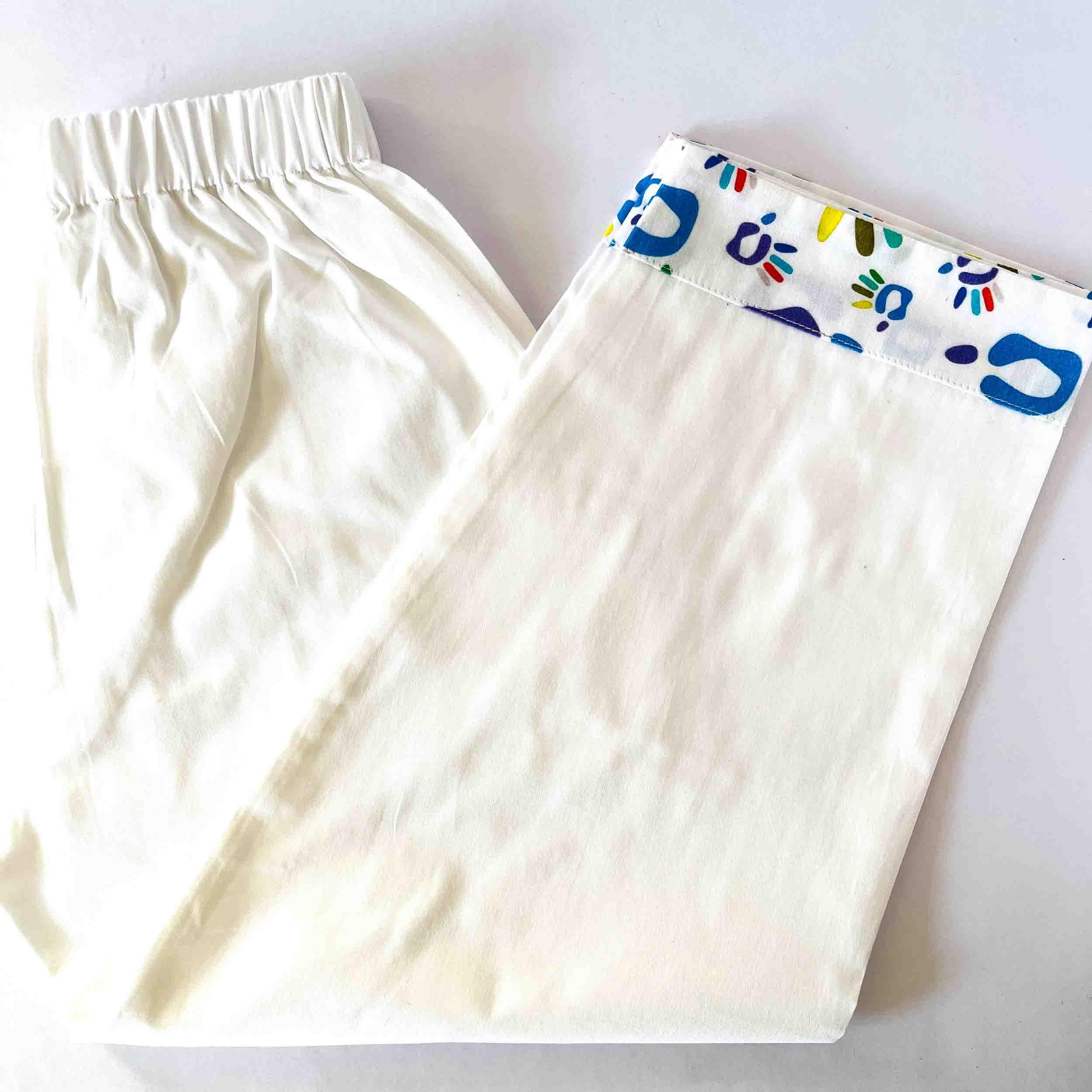 White pants with colorful floral pattern on a white background