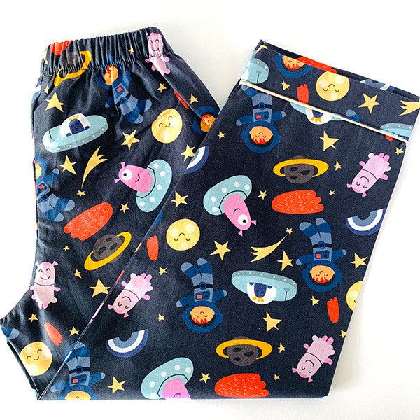 A set of children's night suit with long sleeves, featuring a space-themed print with characters and planets on a dark background.