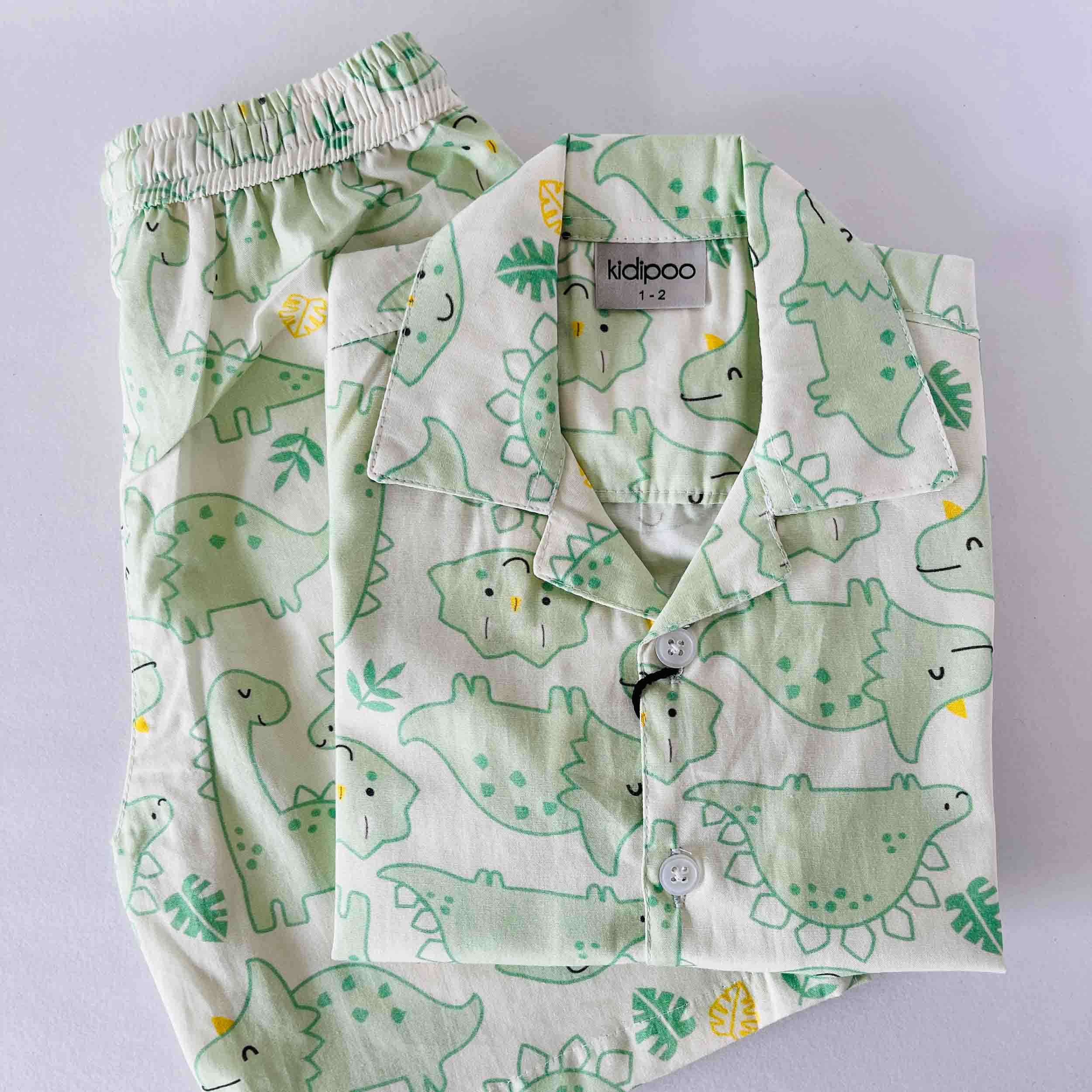 Children's pajama set with dinosaur pattern on a light gray background