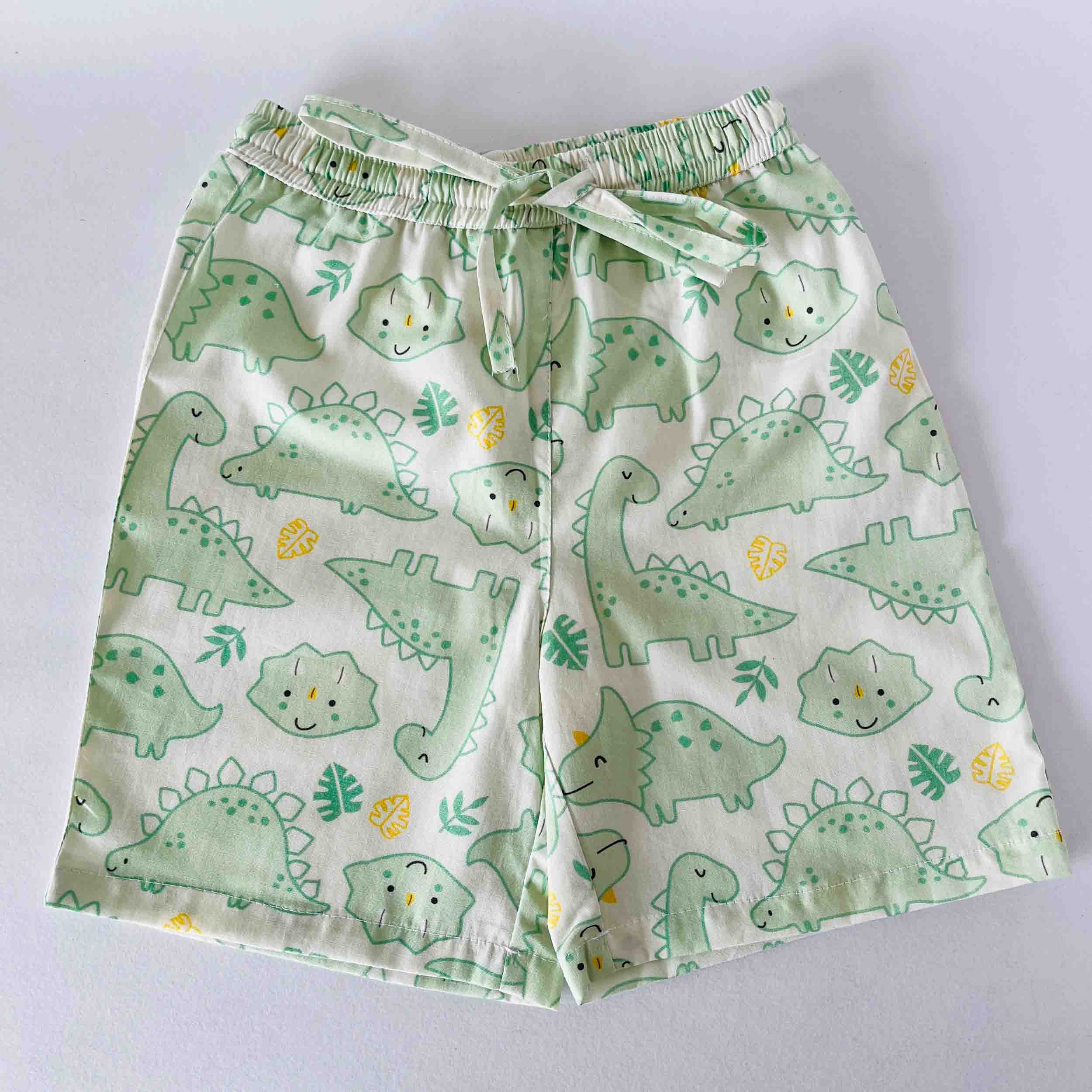 Green dinosaur-patterned shorts on a light gray background