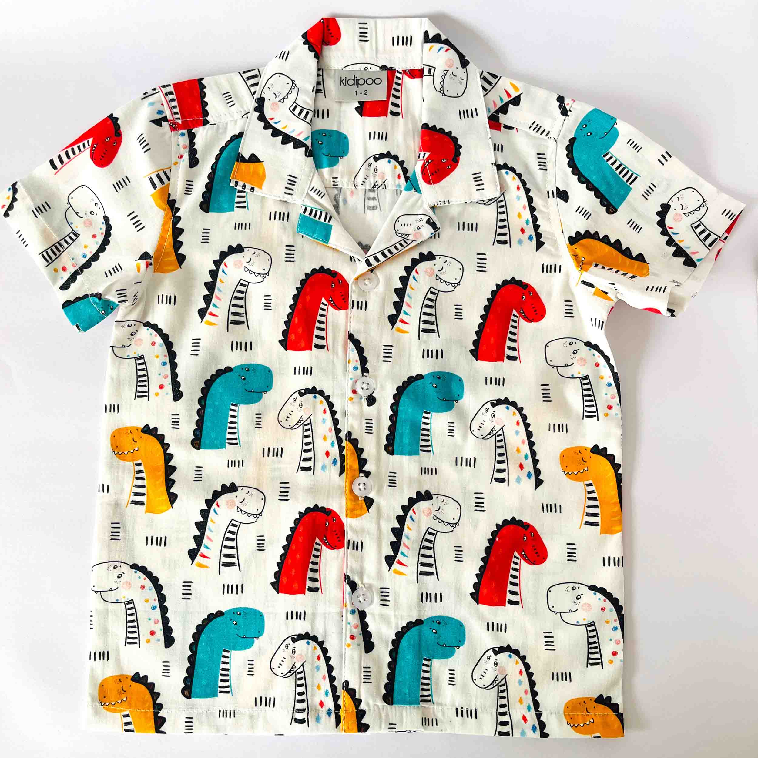 Children's shirt with colorful dinosaur pattern on a white background