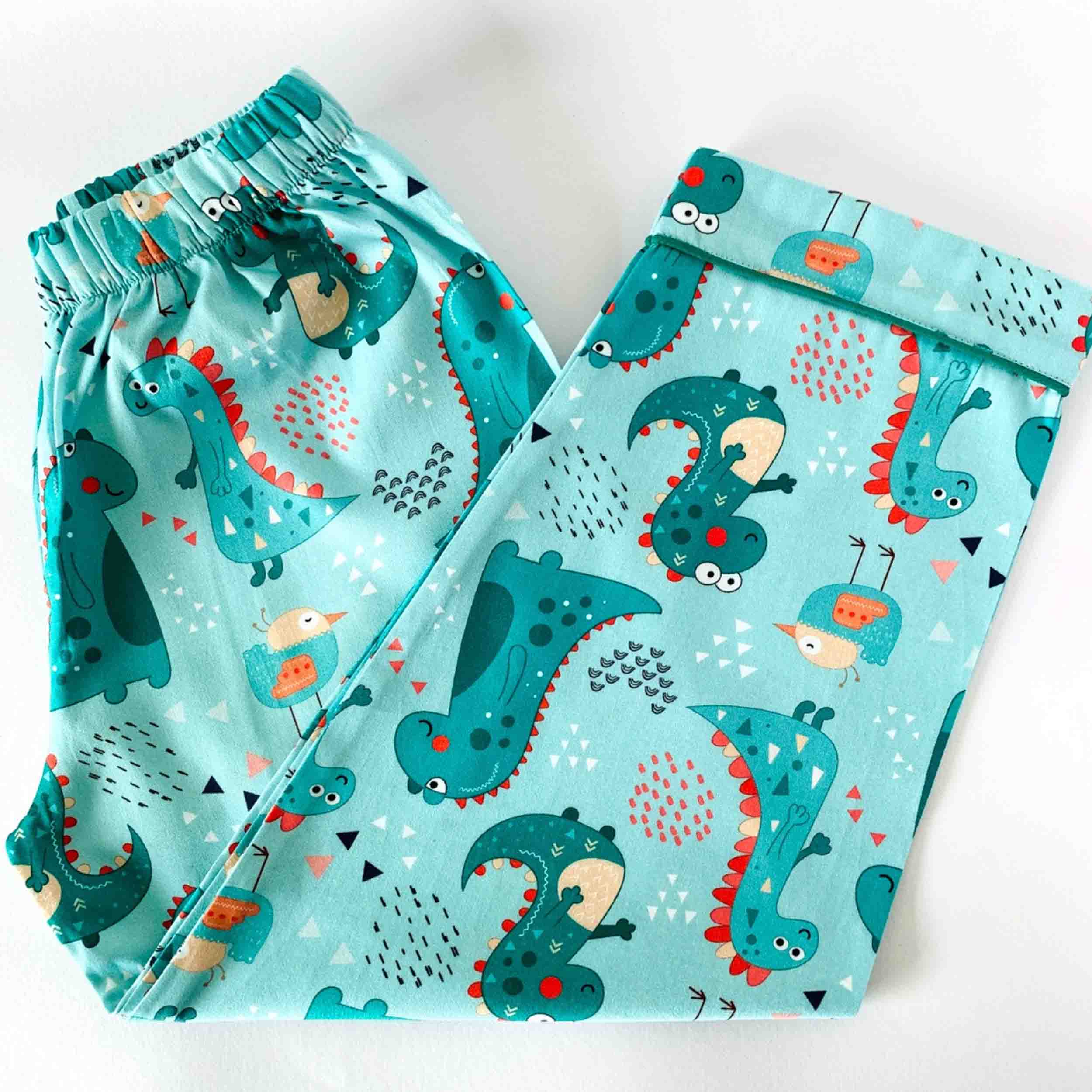 Children's pajama set with dinosaur pattern on a light blue background