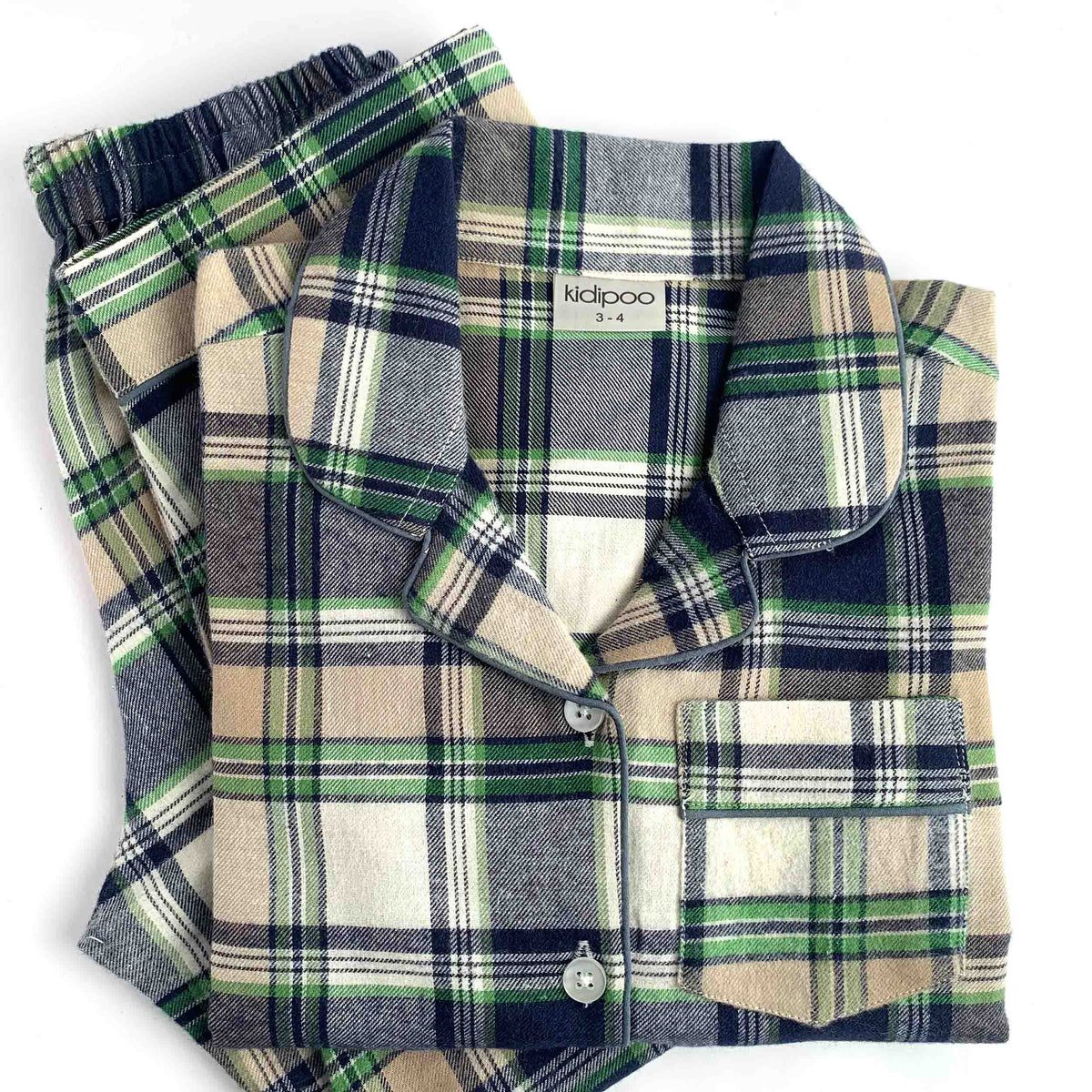 A folded plaid pajama set with a long-sleeve button-front top and matching pants, shown on a plain white background. The fabric has a classic plaid pattern in navy blue, beige, white, and green, with a visible 'kidpoo' brand label inside the collar.
