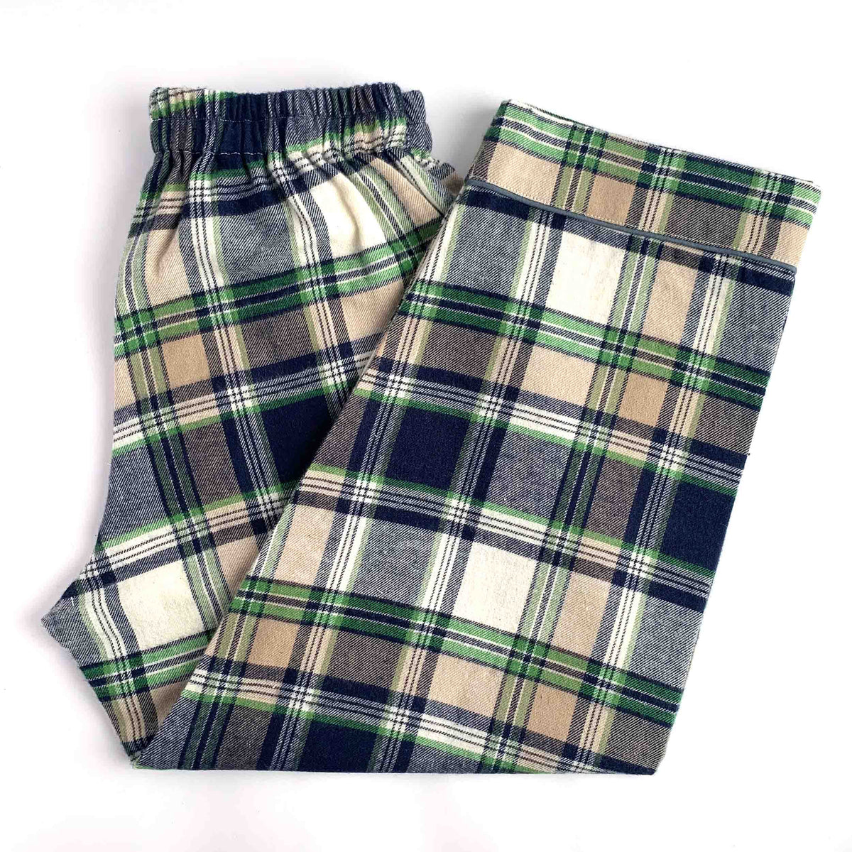 A pair of plaid lounge pants folded on a white background, featuring a classic tartan pattern in navy blue, beige, green, and white.