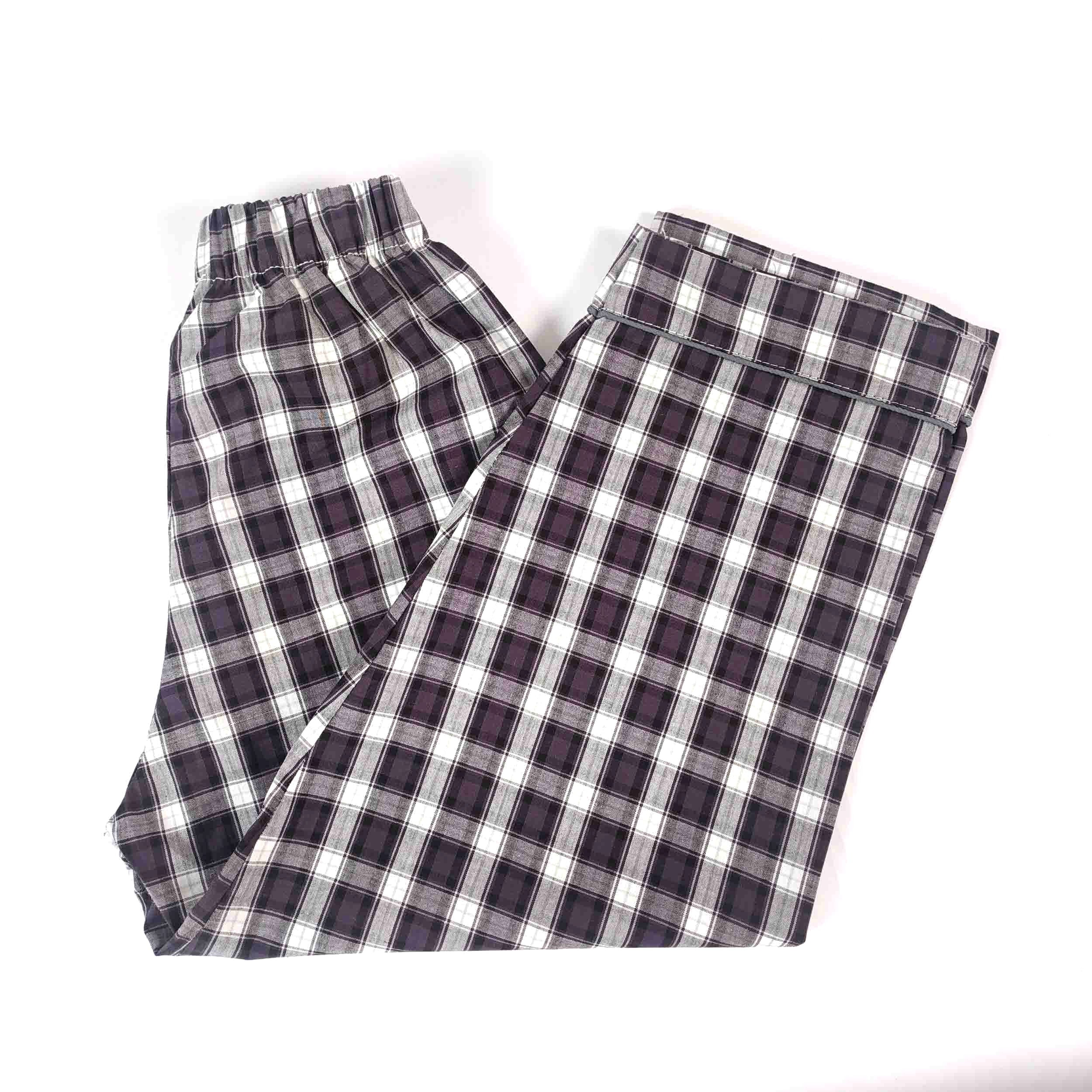 A pair of plaid pajama pants in a dark gray, white, and black checkered pattern, laid flat on a white background.