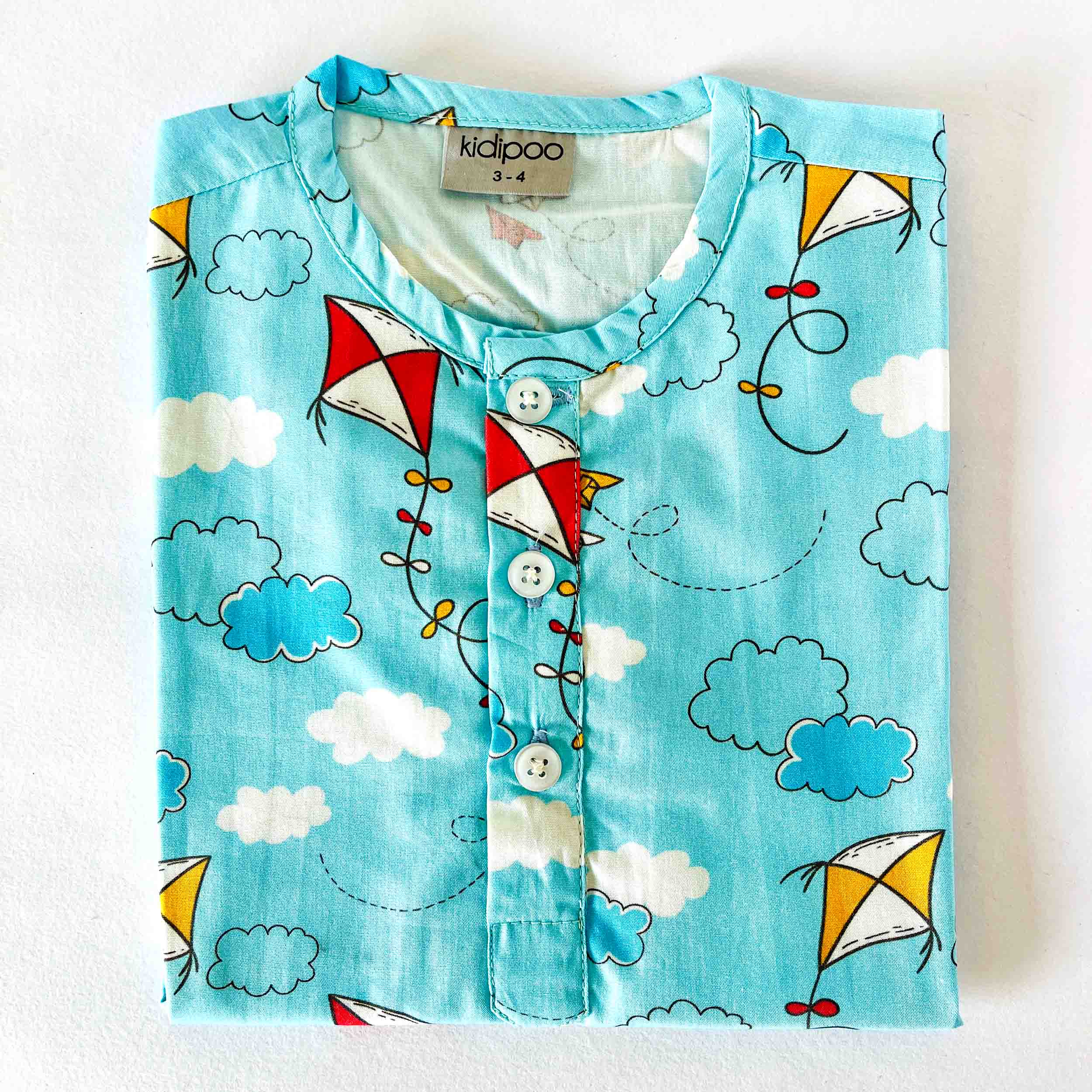 Children's shirt with kite and cloud pattern on a white background