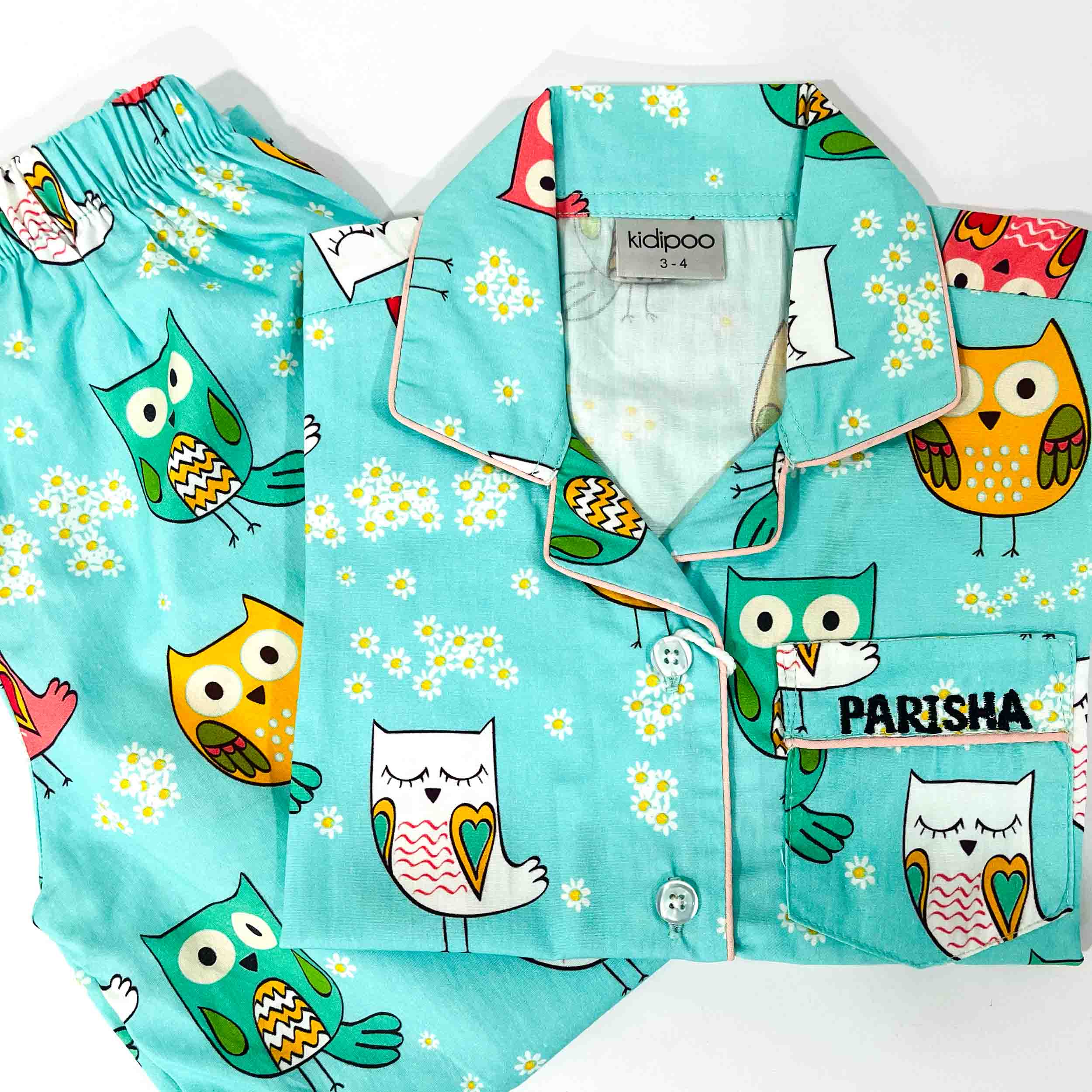 Children's pajama set with owl pattern on a turquoise background