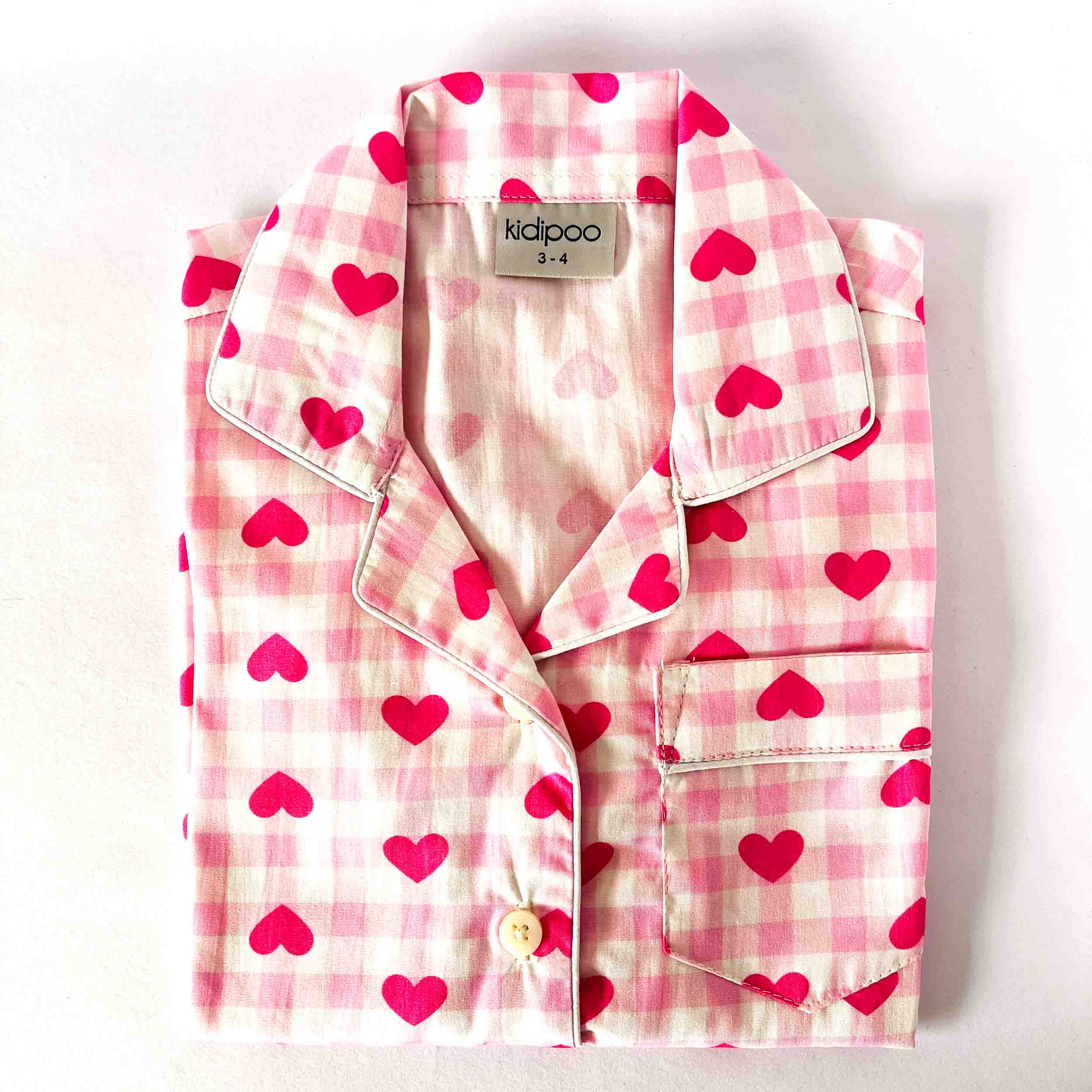 Pink checkered Shirt with heart print on a white background