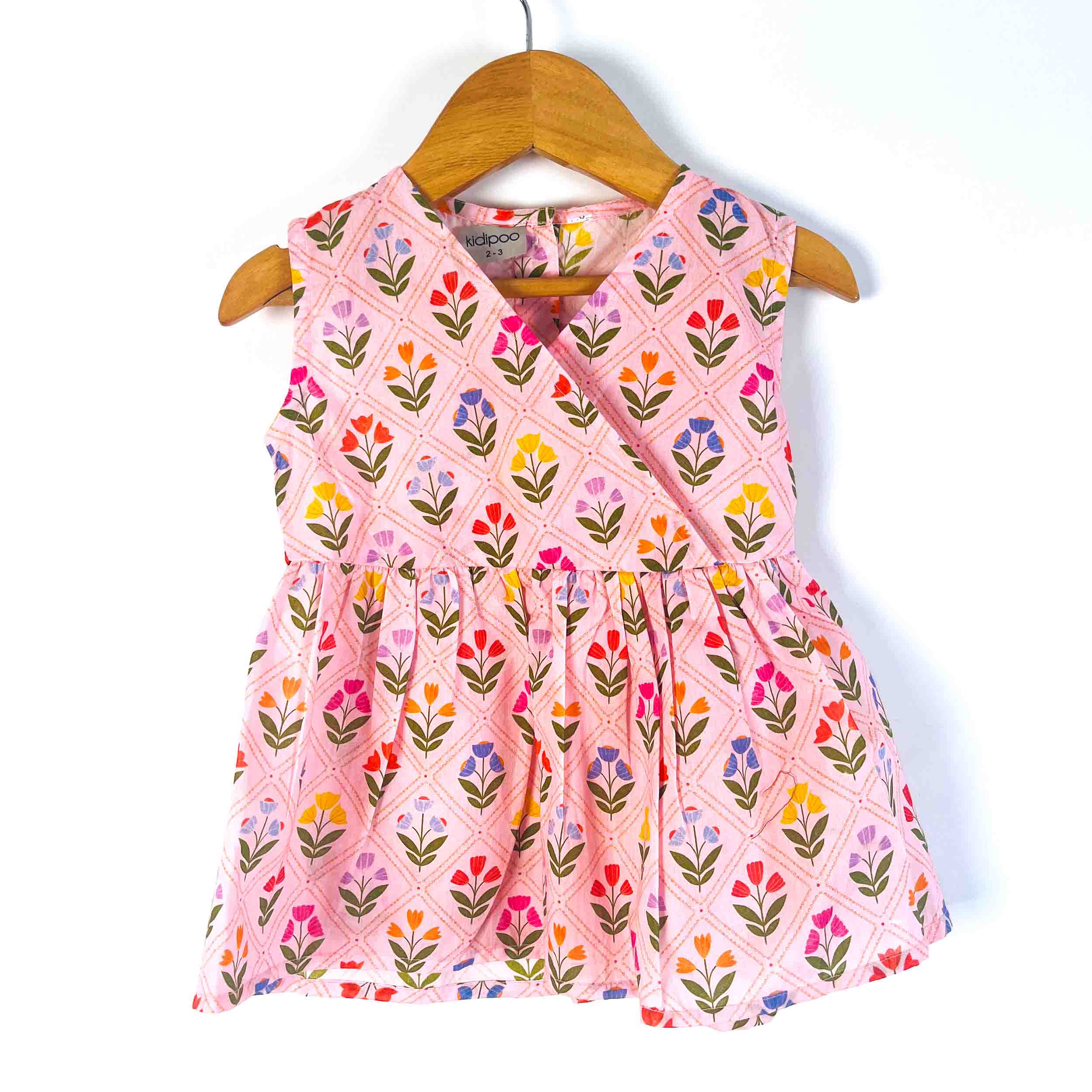Pink Petals sleeveless cotton dress with a V-neck wrap-style design, floral print, and flared silhouette for girls