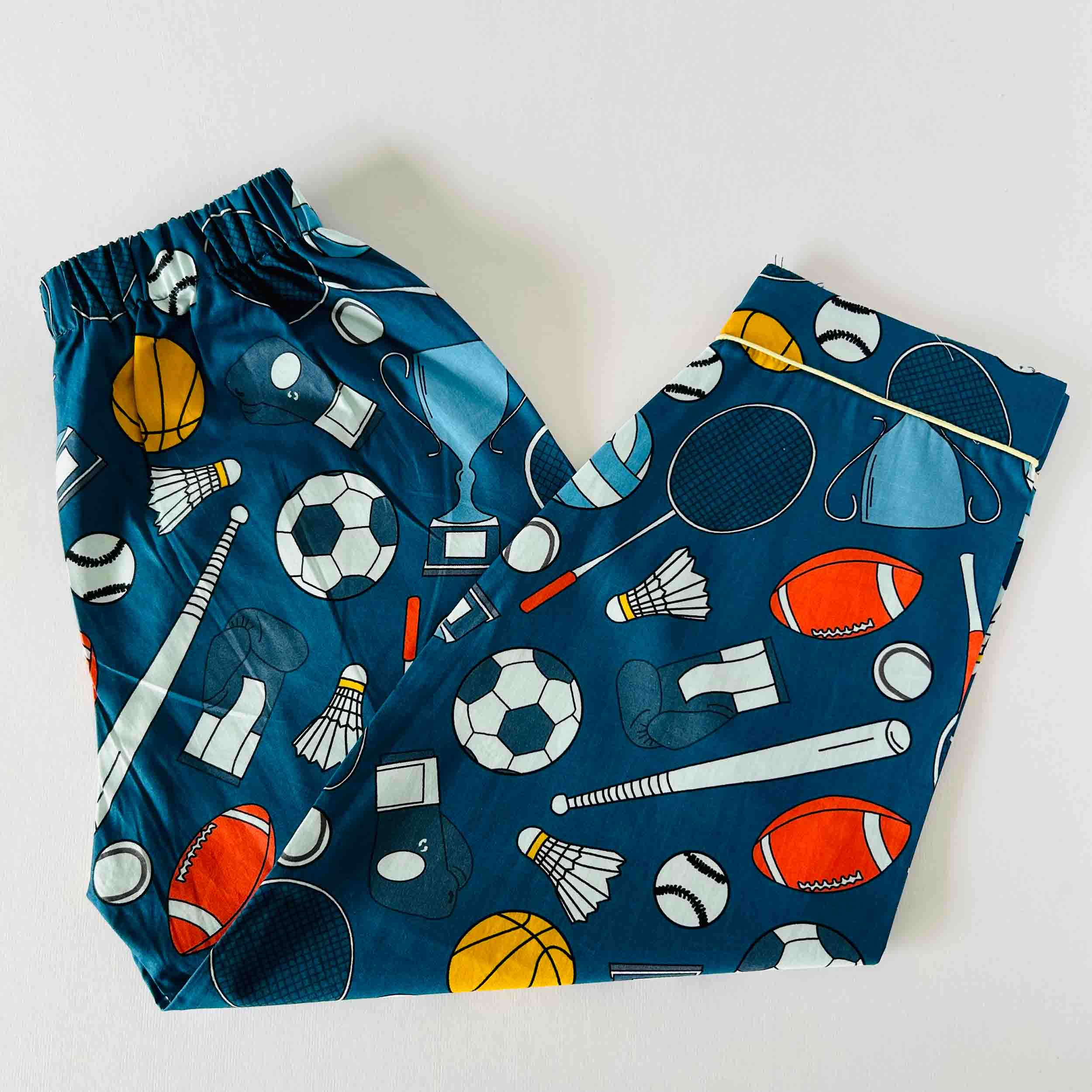 Blue children's pants with sports-themed pattern on a white background
