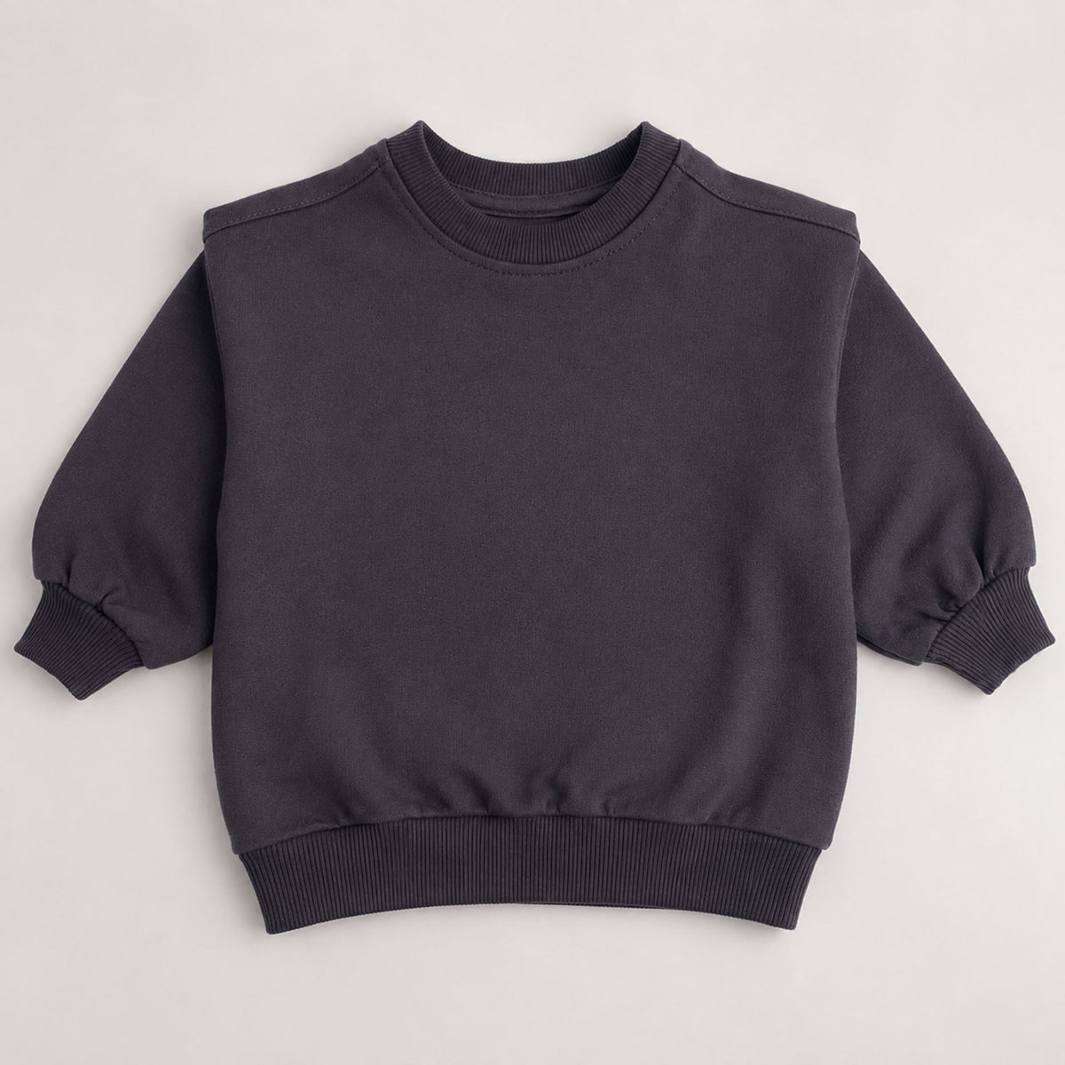 A dark charcoal gray crewneck sweatshirt with long balloon sleeves and ribbed cuffs, hem, and collar, laid flat on a light gray background.