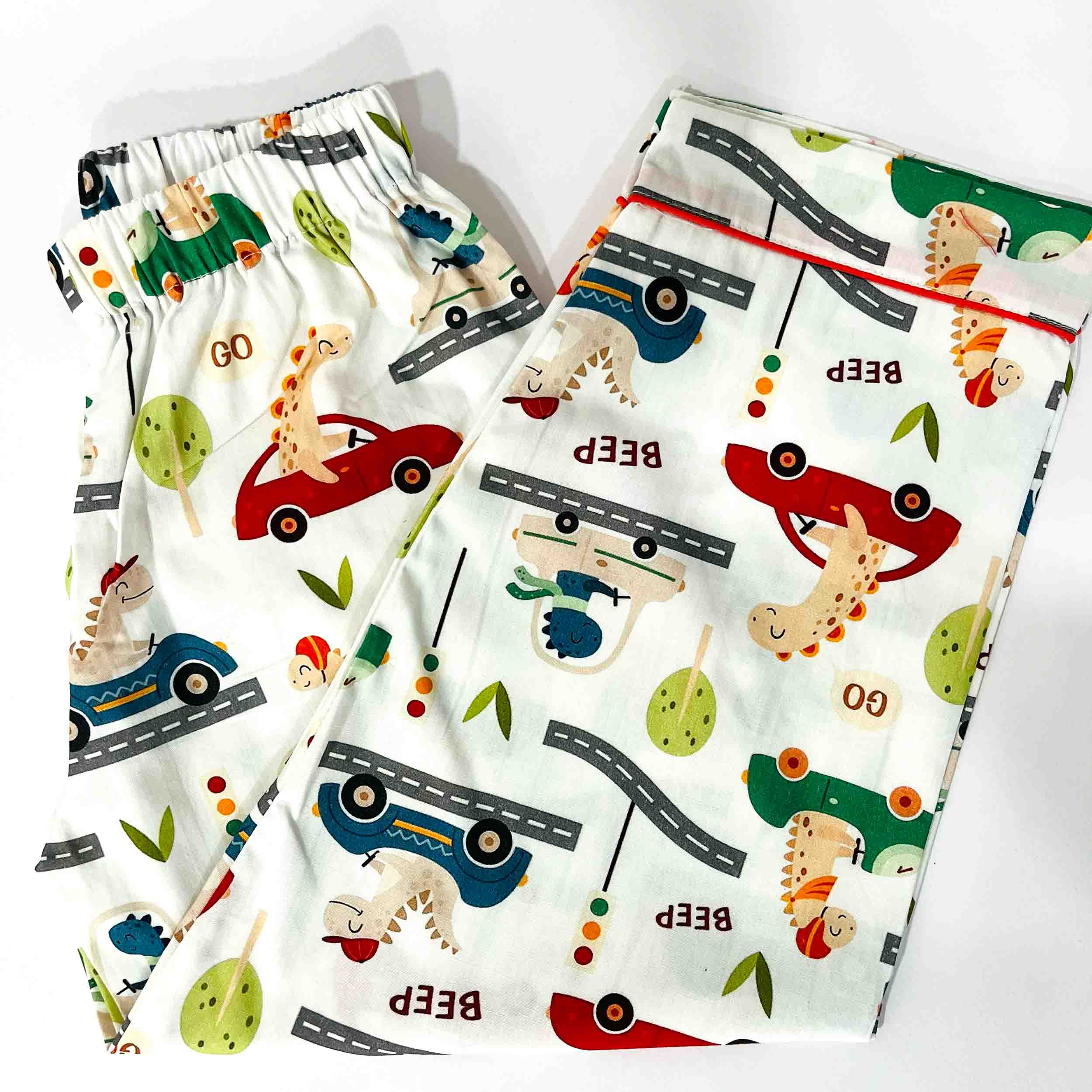 Two pairs of children's shorts with vehicle and animal pattern on a white background