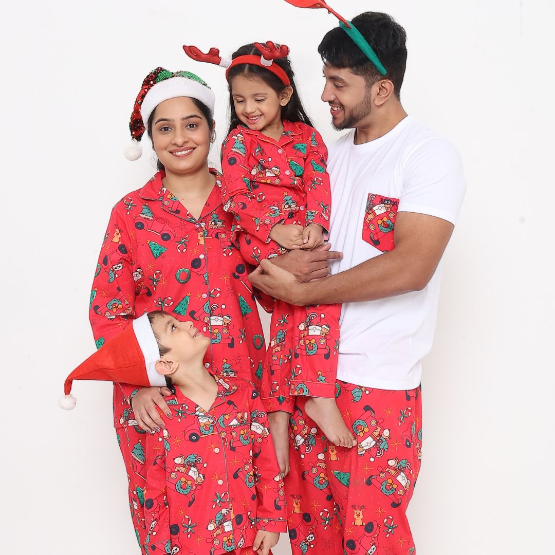 Family wearing matching red Christmas car print cotton night suits sitting together smiling