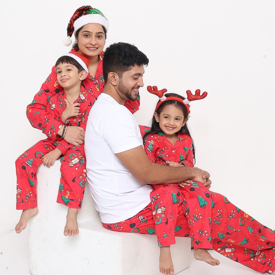 Family wearing matching red Christmas car print cotton night suits sitting together smiling